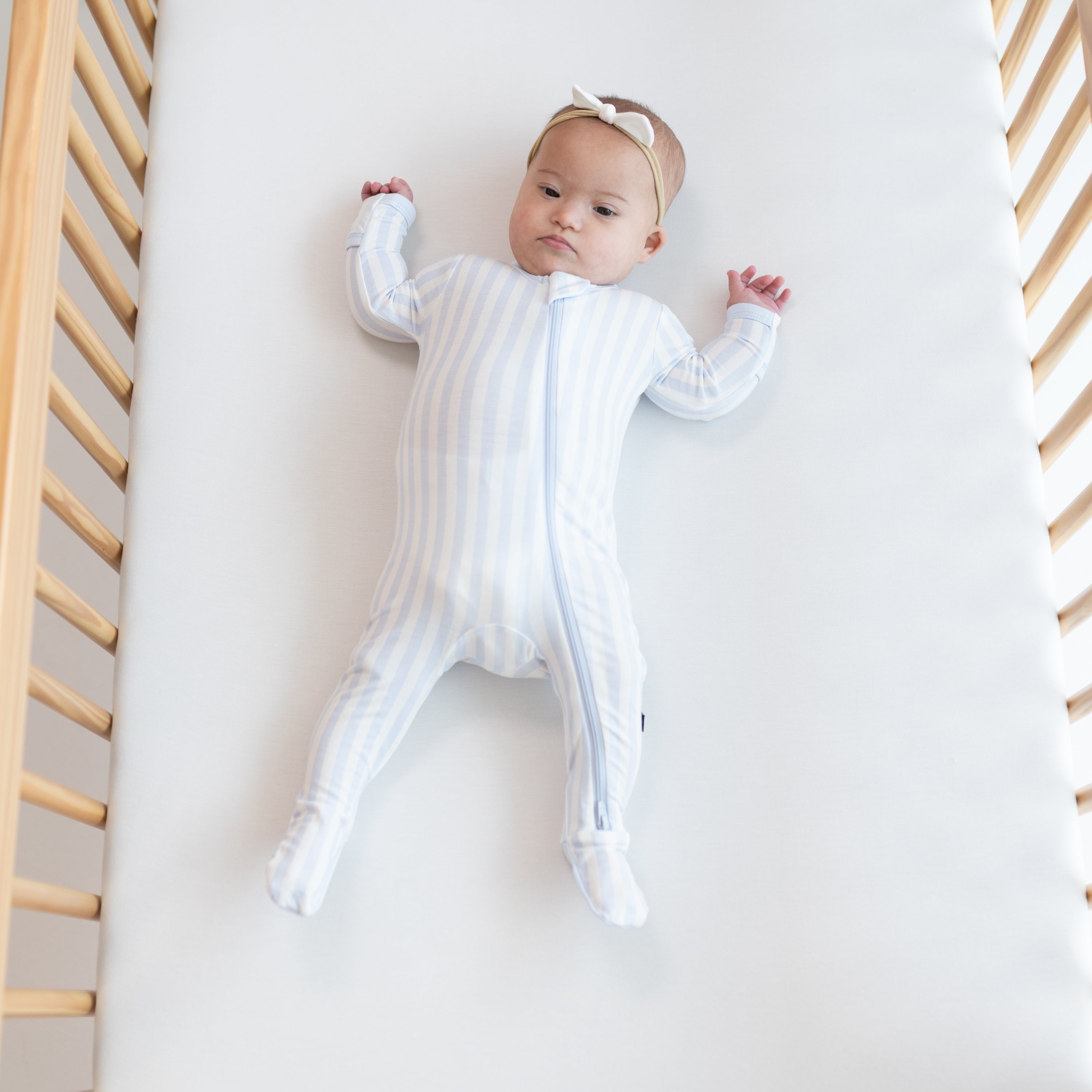 Infant wearing Zippered Footie pajamas in Small Mist Stripe