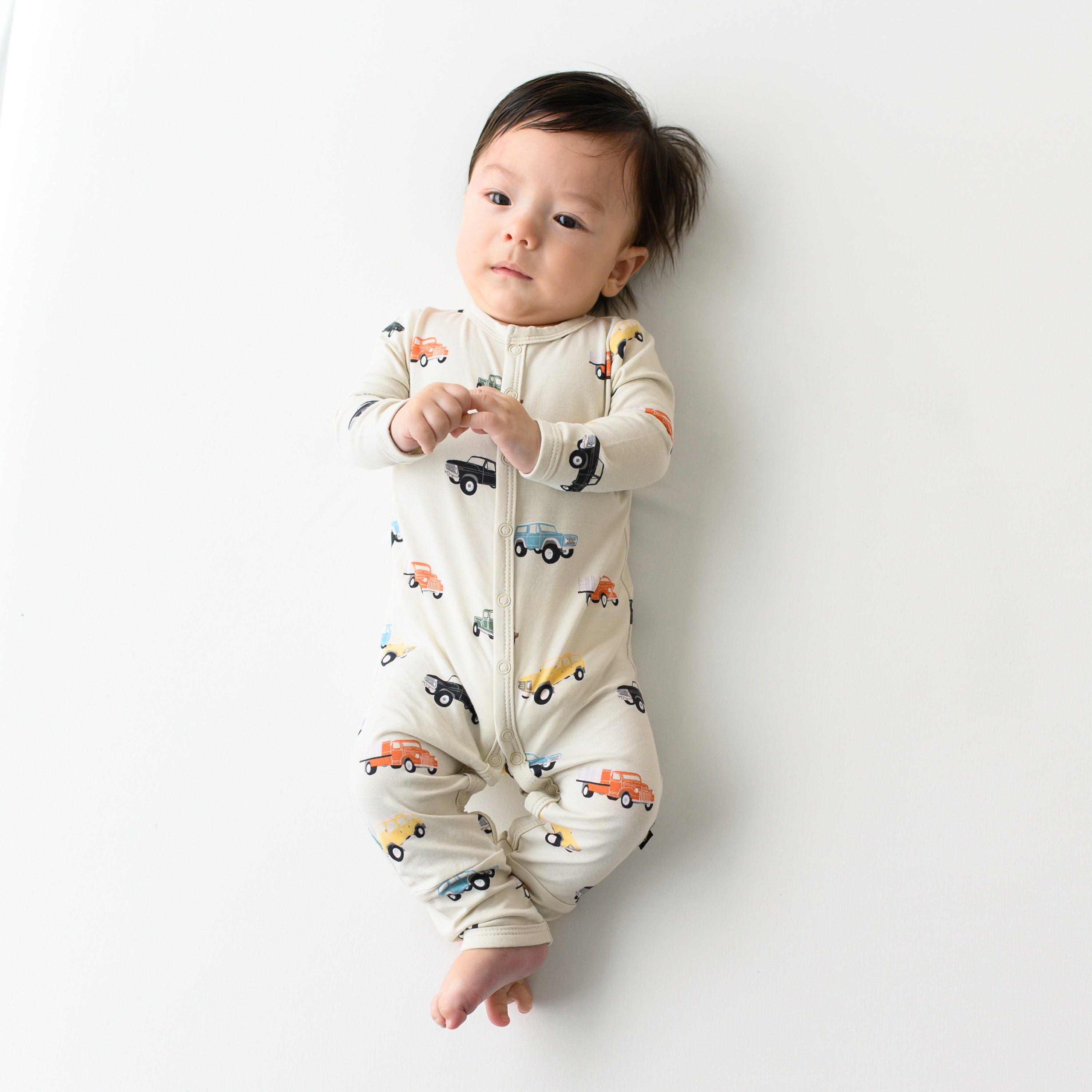 Baby wearing Snap Romper Pajamas in Vintage Truck