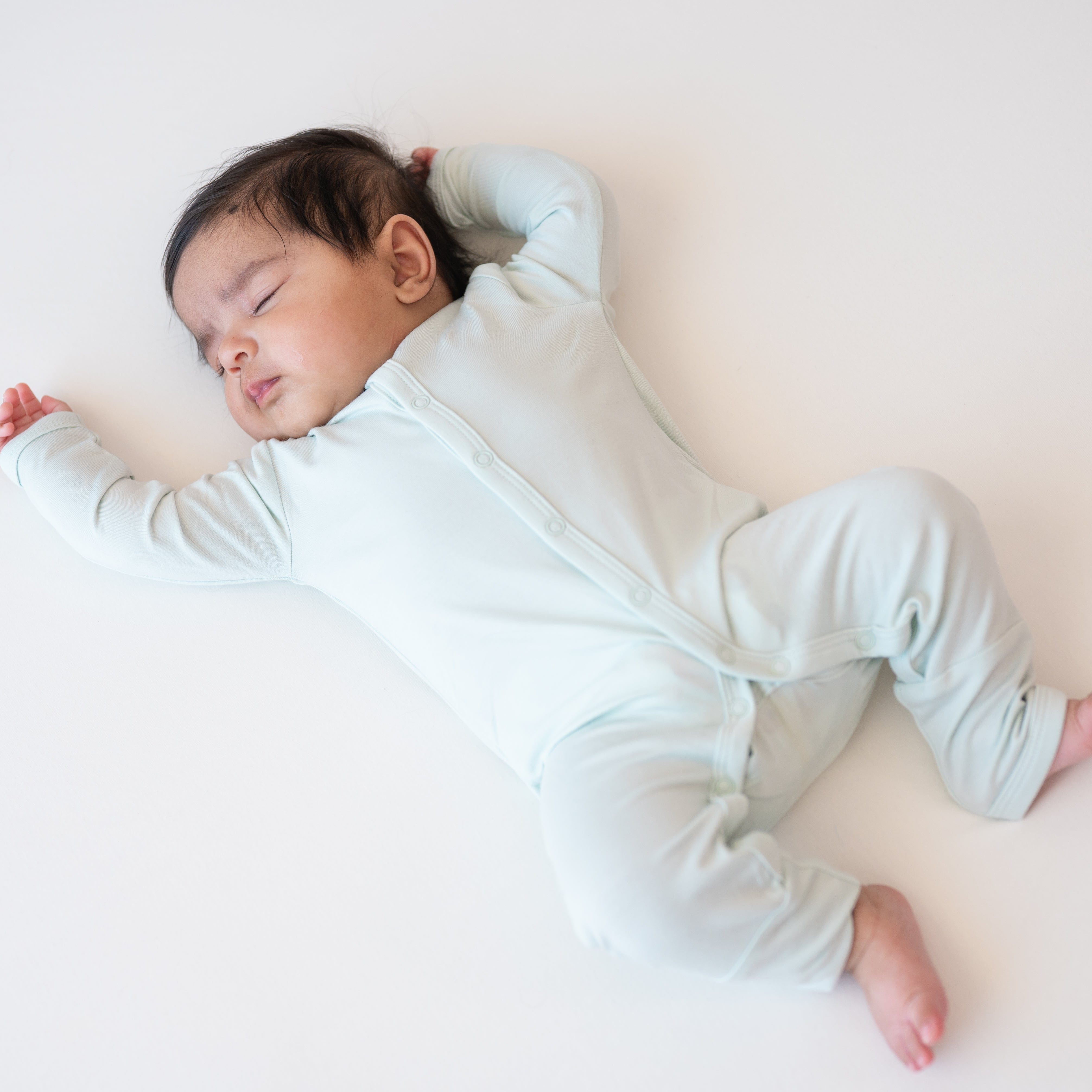 Sleeping baby wearing the Romper in Dew