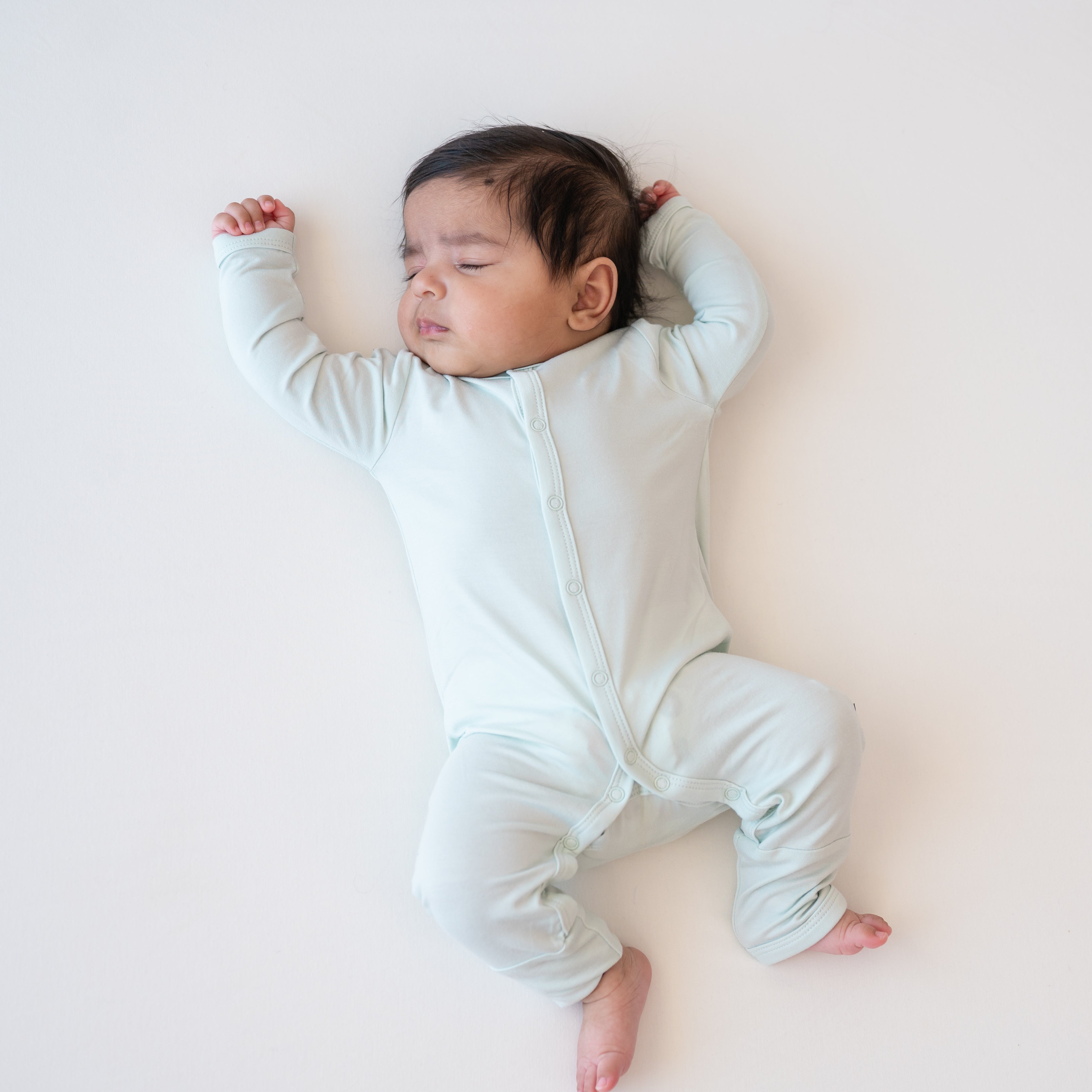 Sleeping baby wearing the Romper in Dew