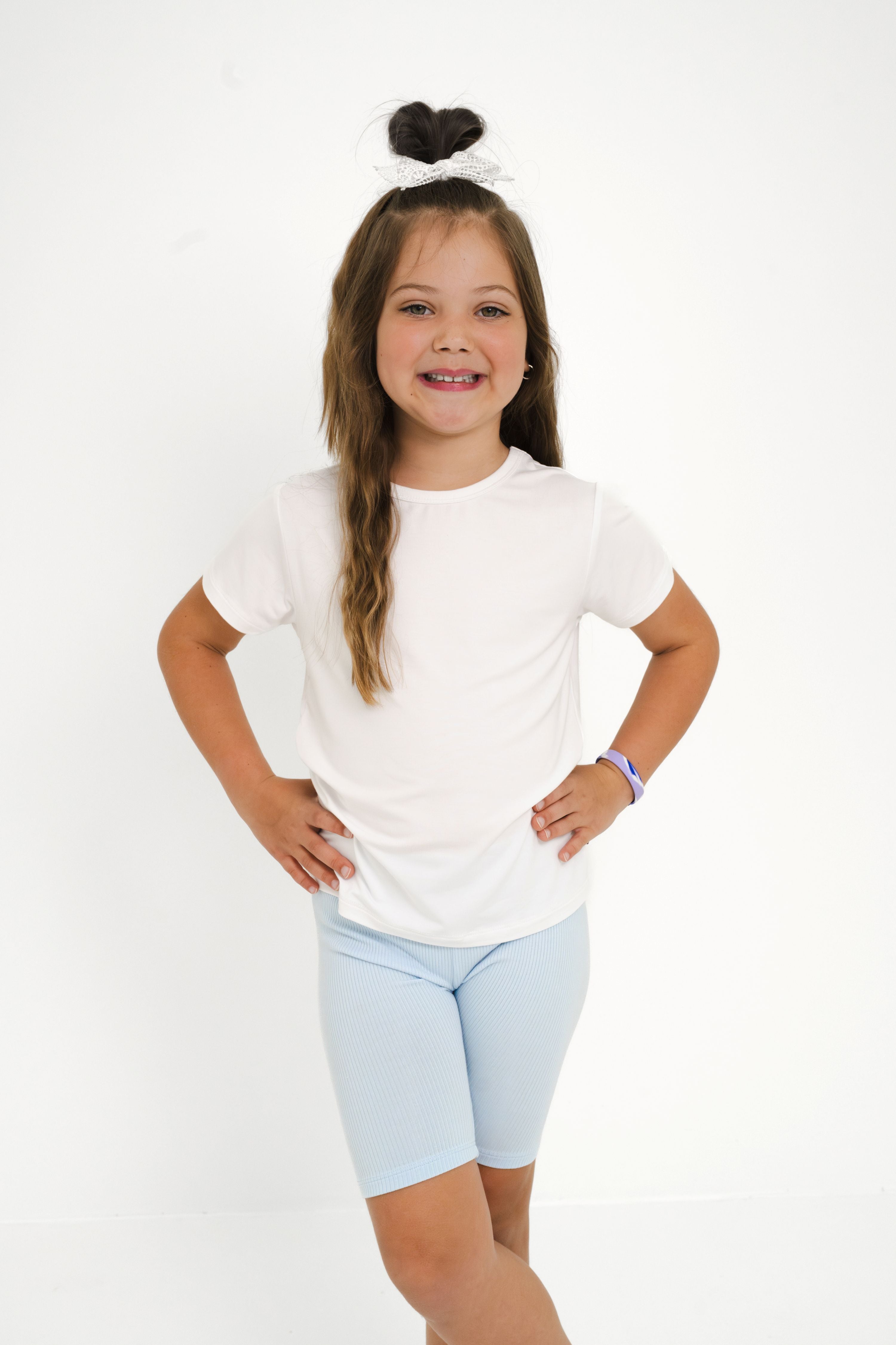 Young girl posing wearing the Toddler Basic Tee in Snow paired with light blue toddler biker shorts