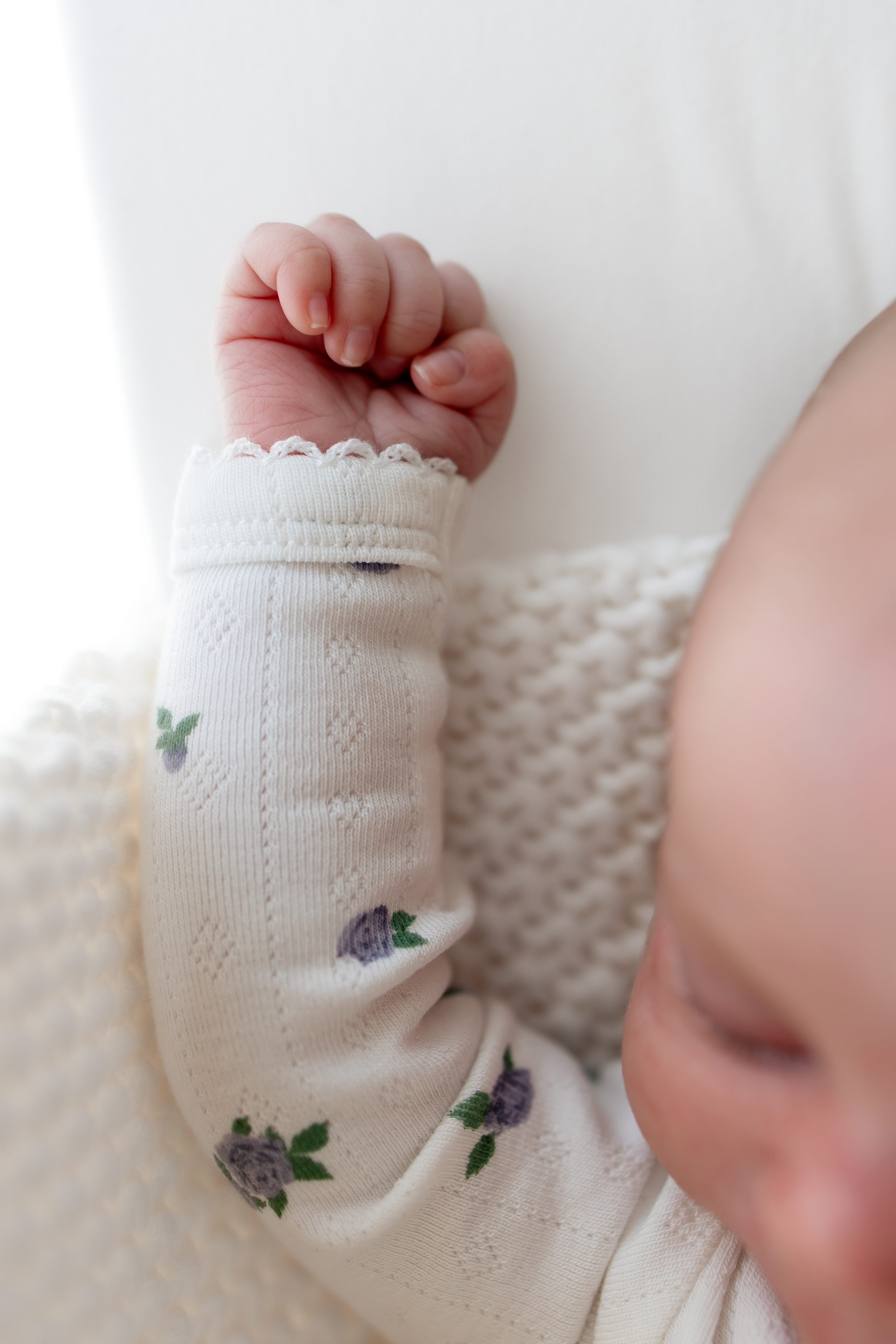 Close up of the arm showing the picot trim on the Pointelle Zippered Footie in Spray Rose