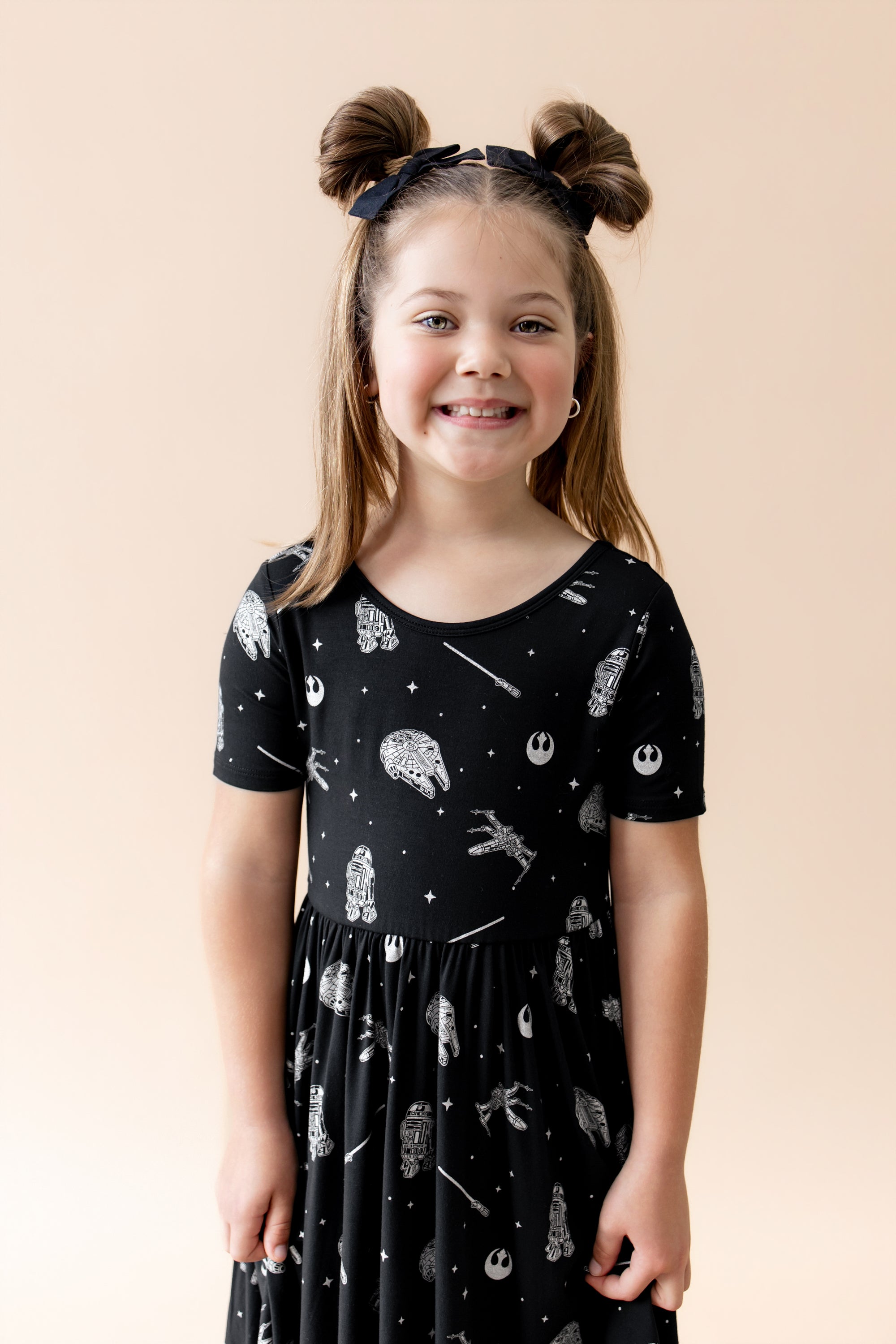 Close up of young smiling girl wearing the Twirl Dress in STAR WARS™