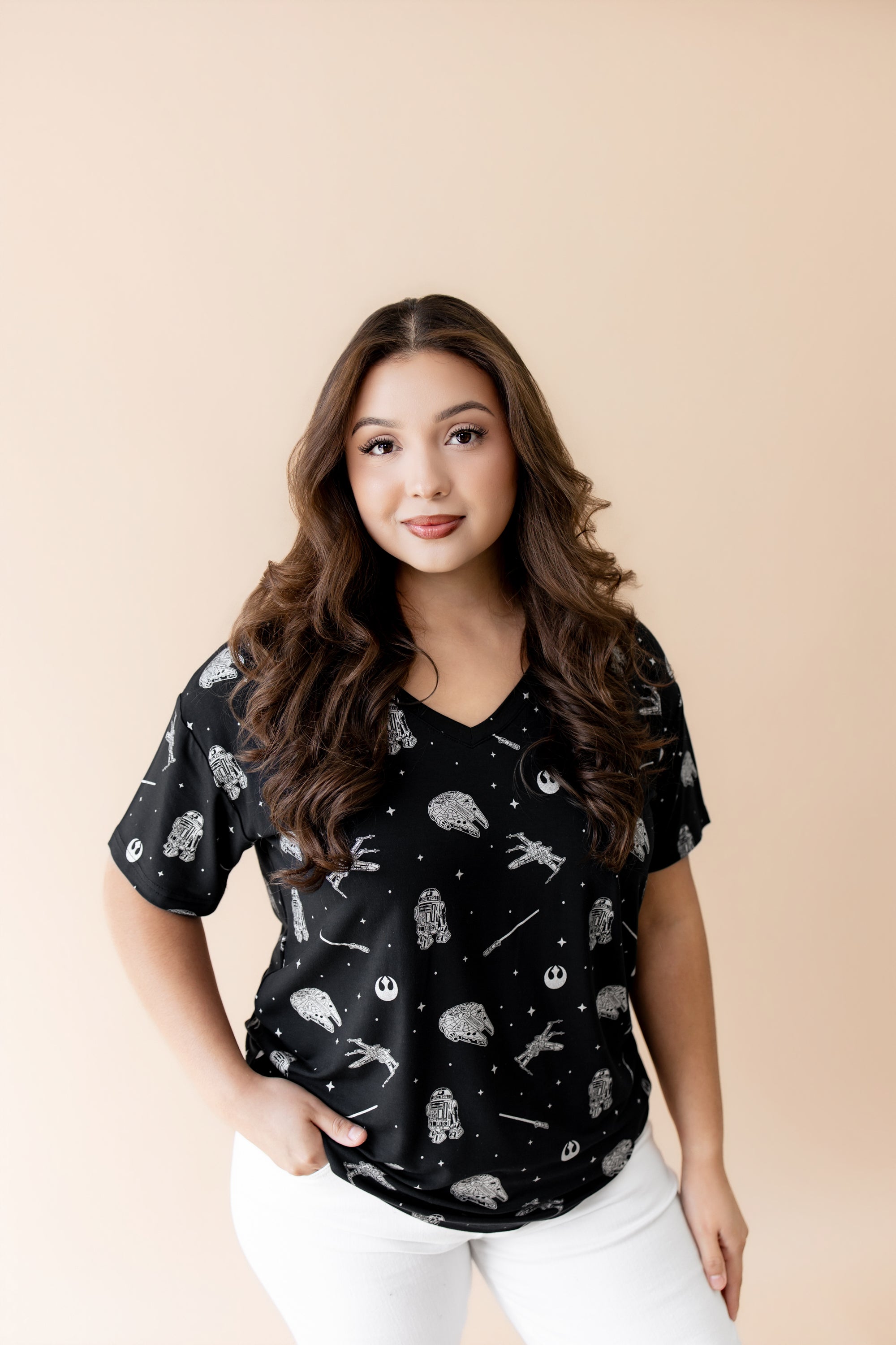 Female modeling the Women's Relaxed Fit V-Neck in STAR WARS™ paired with white pants