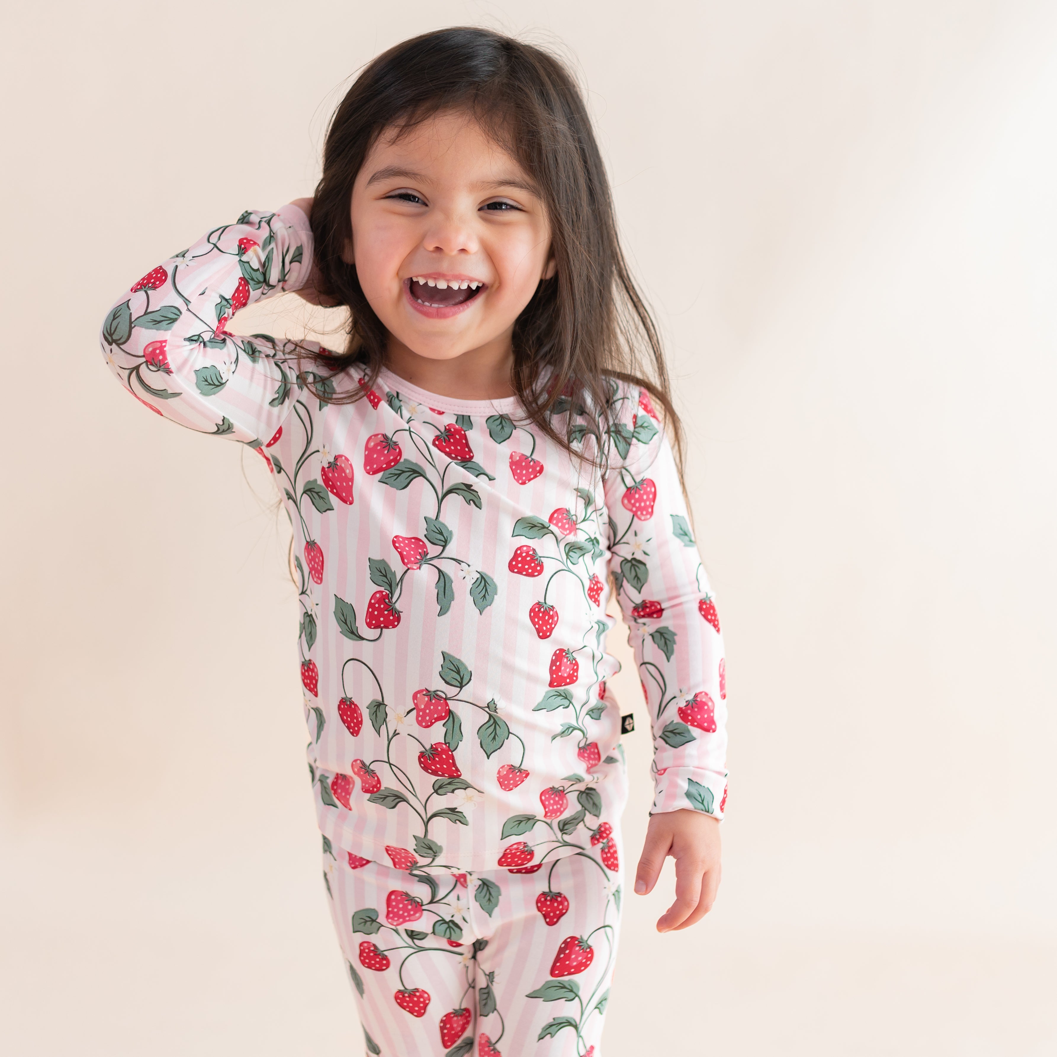 Close up of a young girl posing wearing the Long Sleeve Pajamas in Strawberry Fields