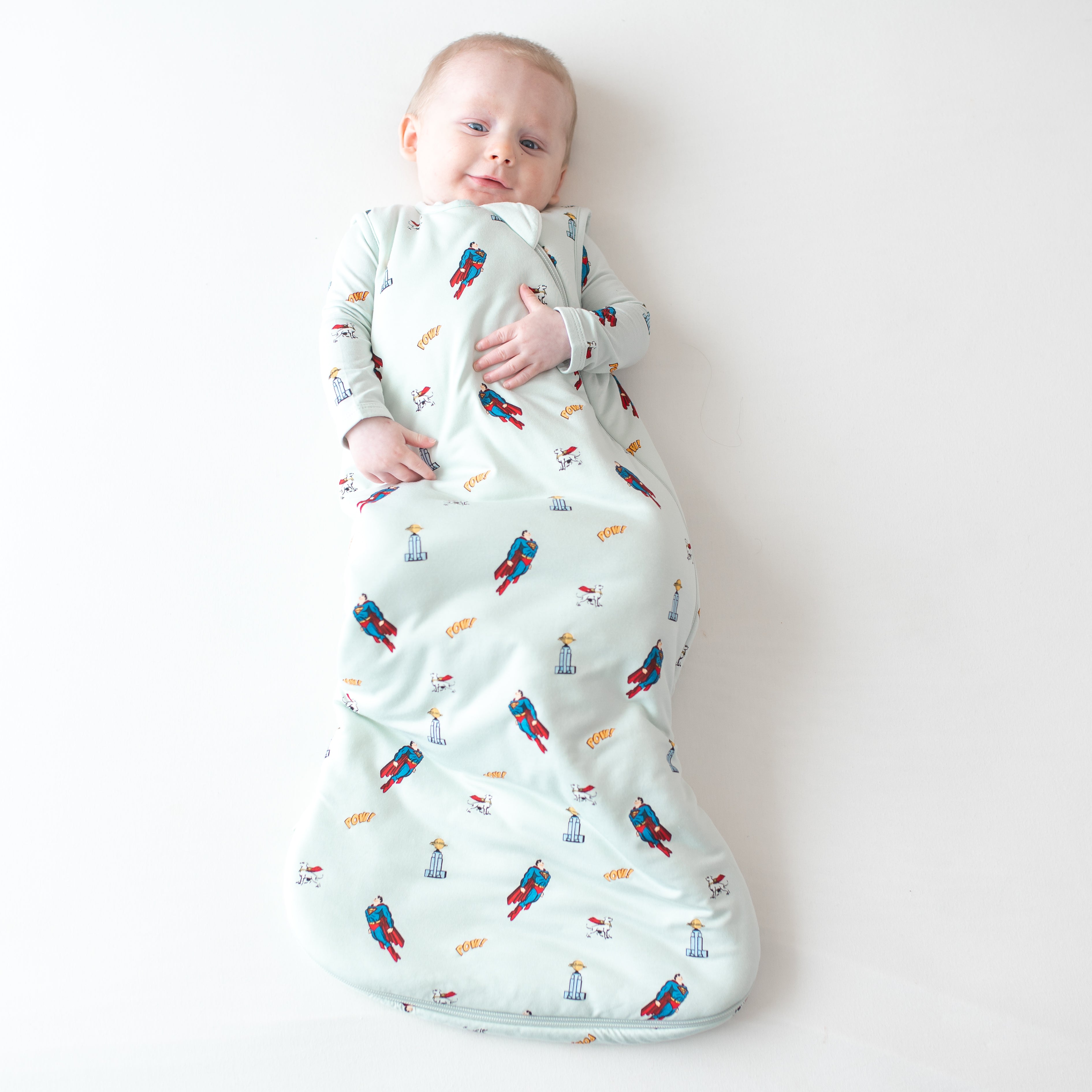 Infant wearing the Sleep Bag in Superman™ 1.0 paired with a matching long sleeve romper