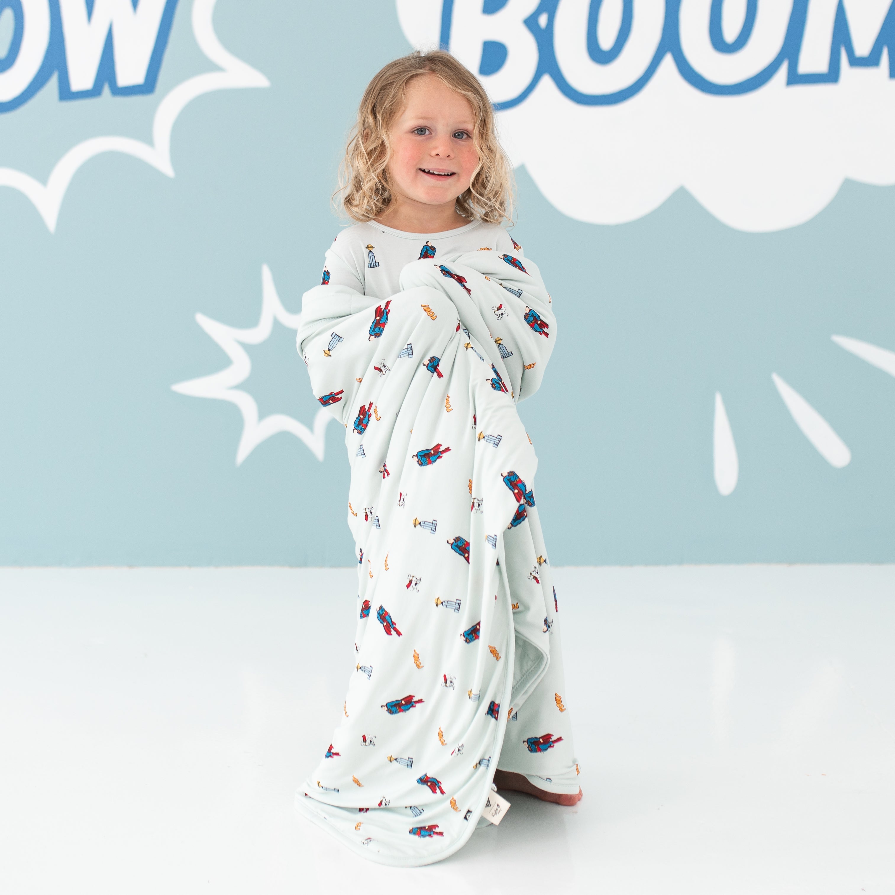 Child wrapped in Superman™ Toddler Blanket in 1.0 TOG