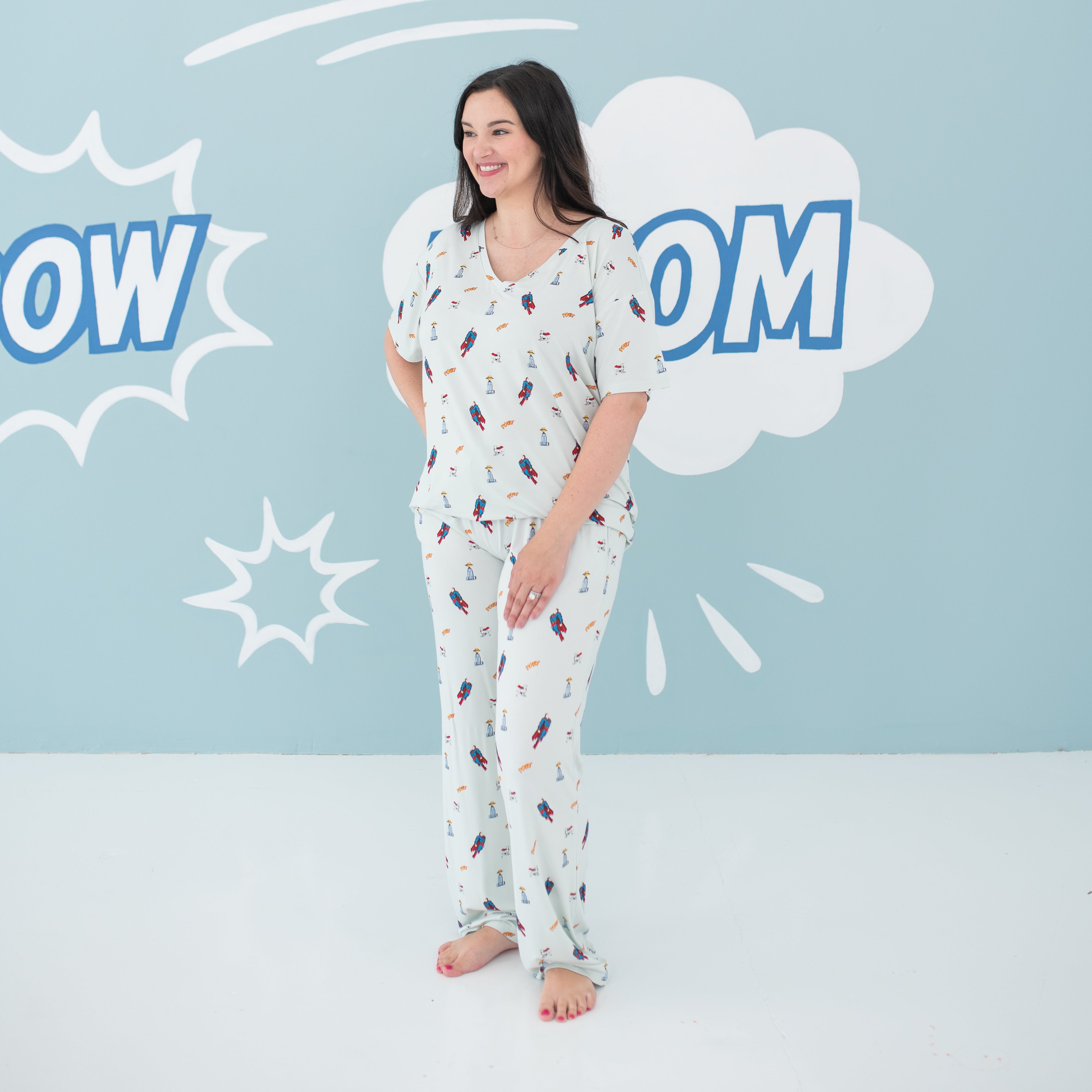 Smiling female model wearing the Women's Lounge Pants in Superman™ paired with the matching Women's Relaxed Fit V-Neck