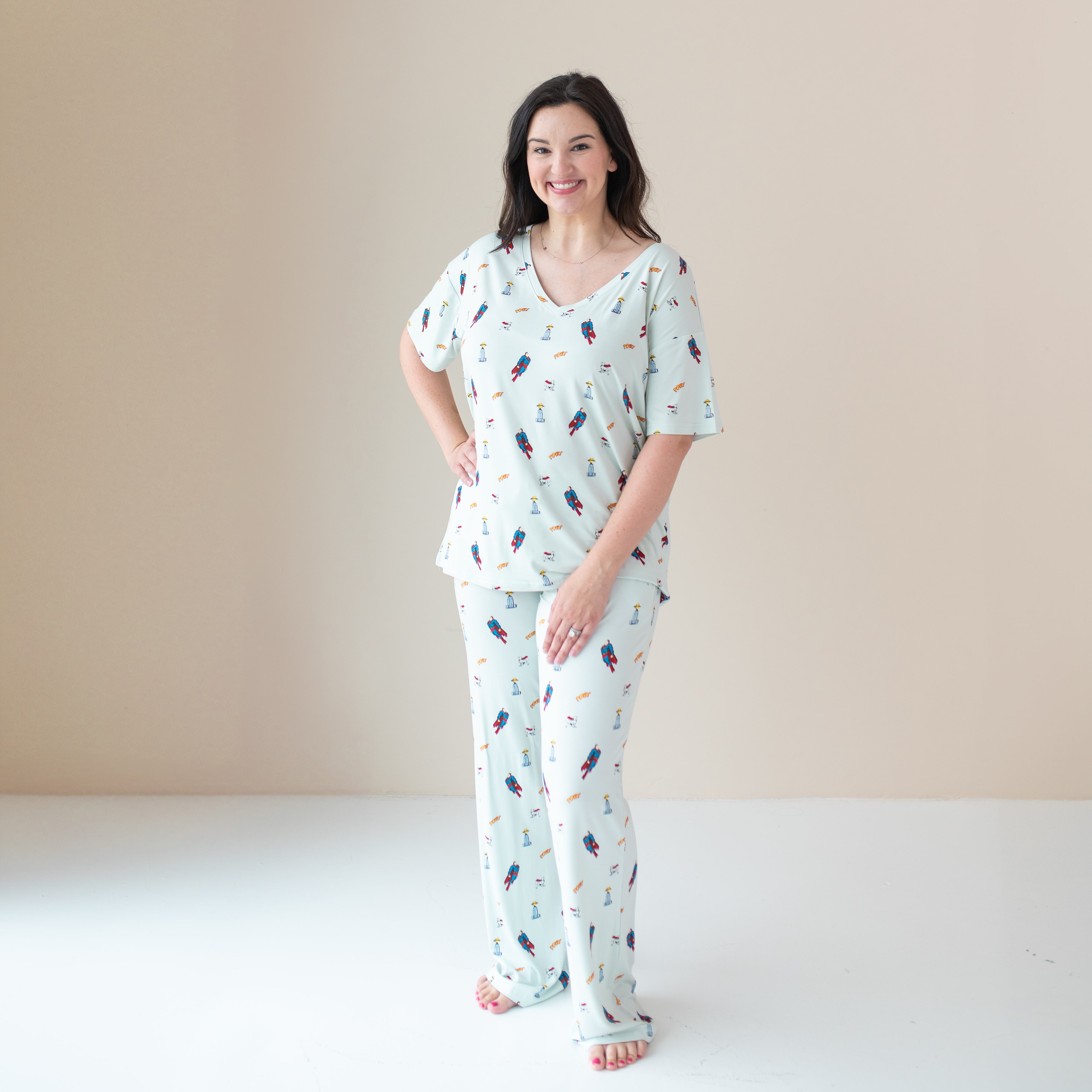 Smiling female model wearing the Women's Lounge Pants in Superman™ paired with the matching Relaxed Fit V-Neck
