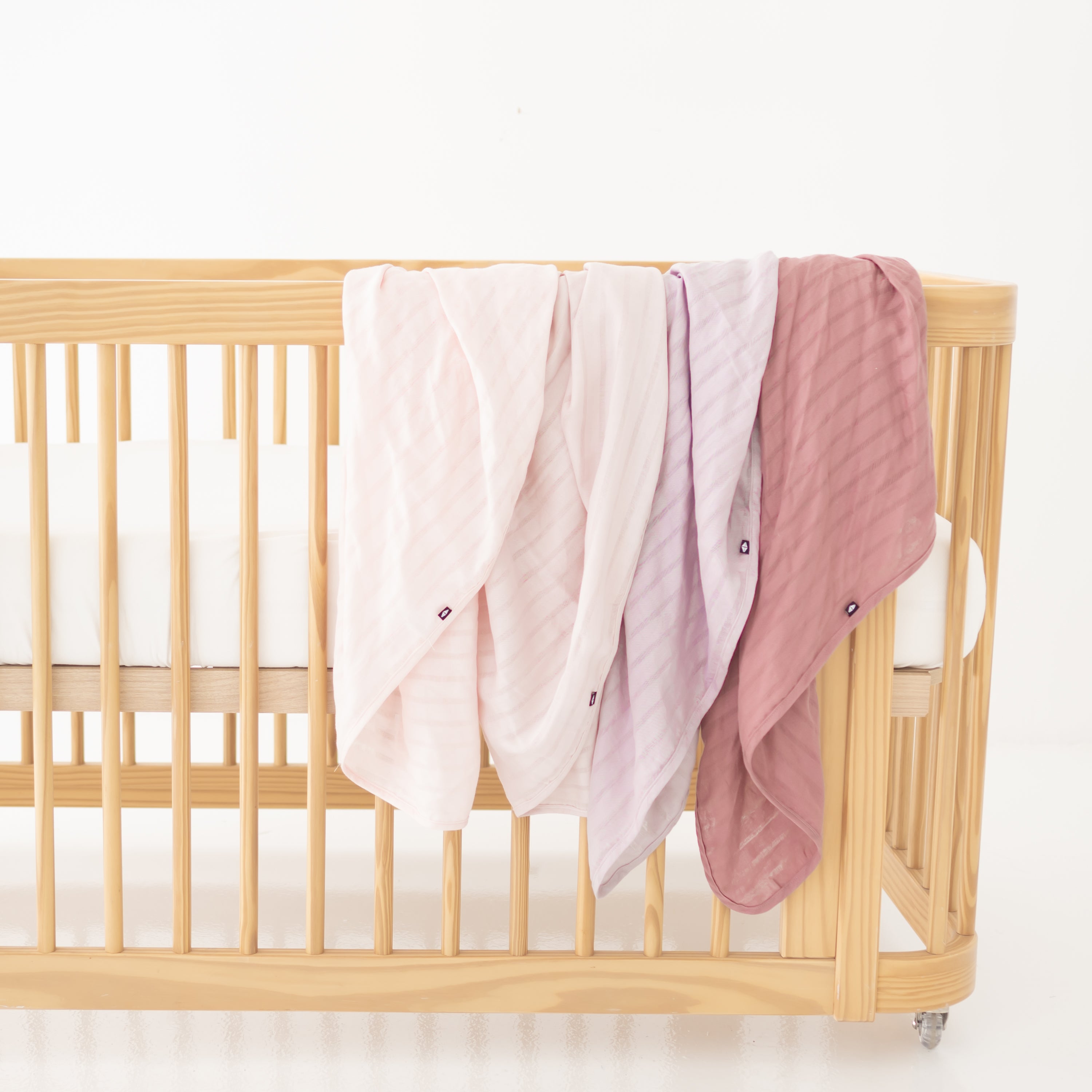 Pink Bamboo Muslin Swaddle Blankets Draped Over Crib