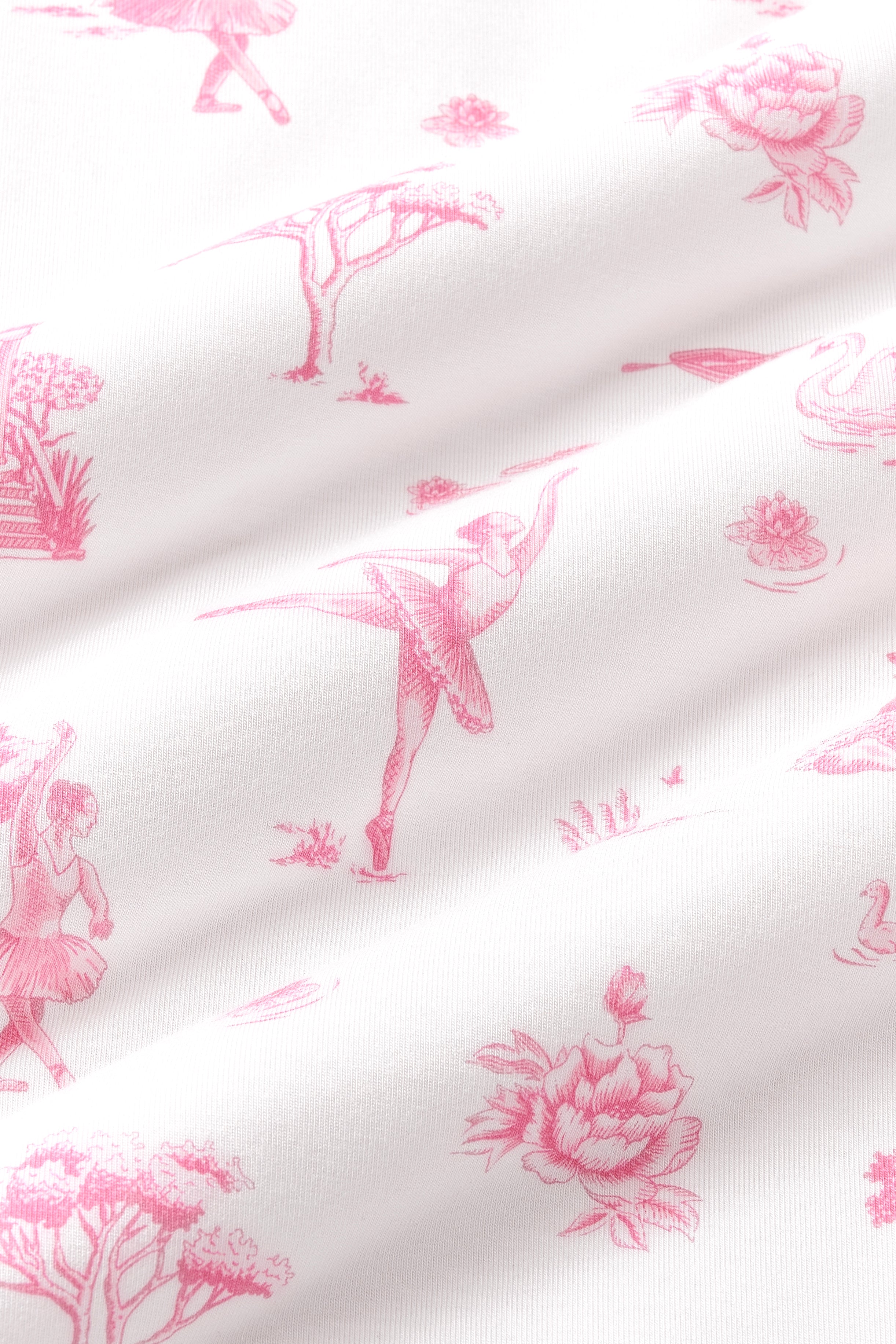 Close up of the bamboo fabric: A dusty rose toile print on a white background, featuring ballet dancers in tutus, small gazebos with stairs, water lilies on lily pads, reeds, rowboats, trees, swans, cygnets, and flowers.