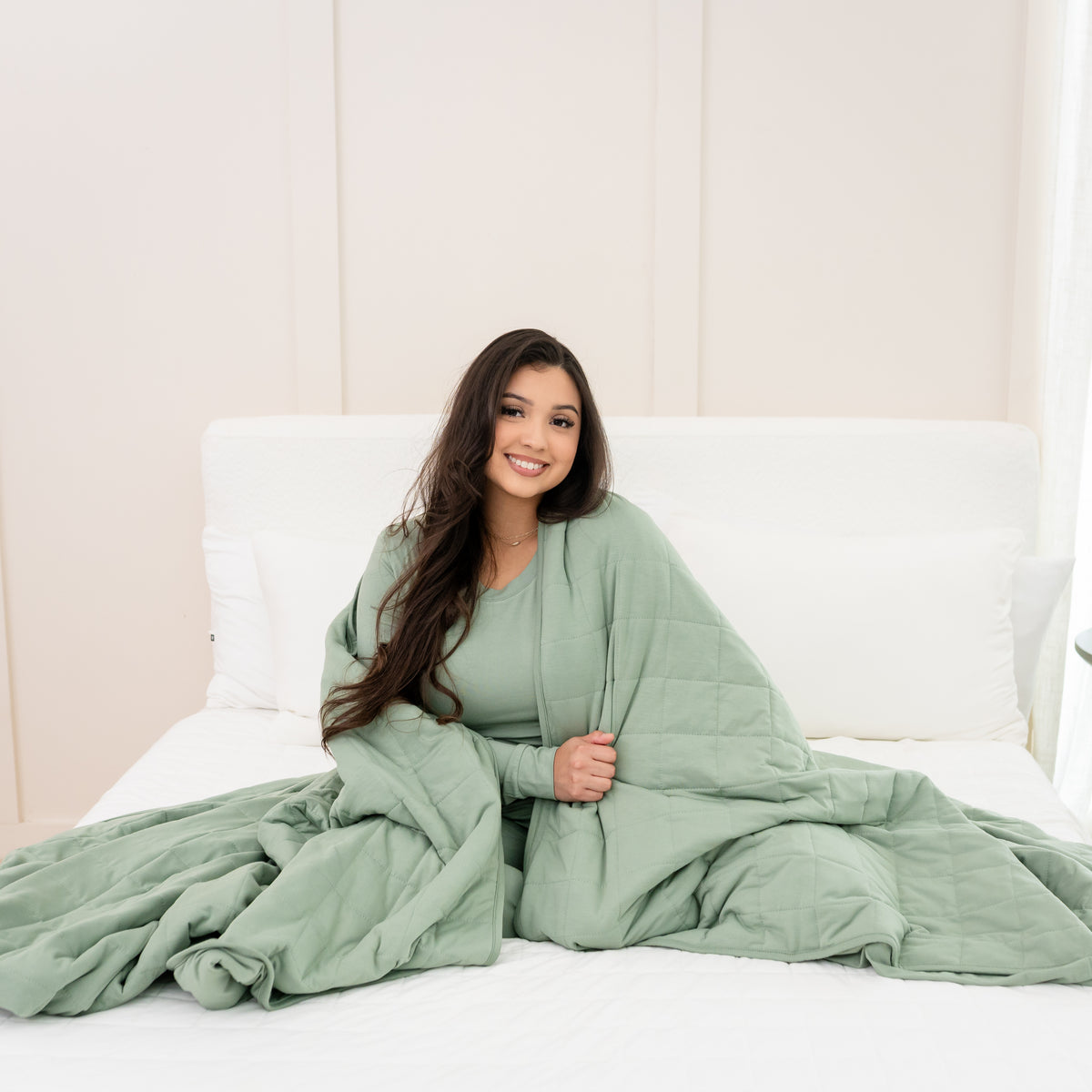 Woman in Thyme Jogger set wrapped in Adult Quilted Blanket in Thyme 2.5