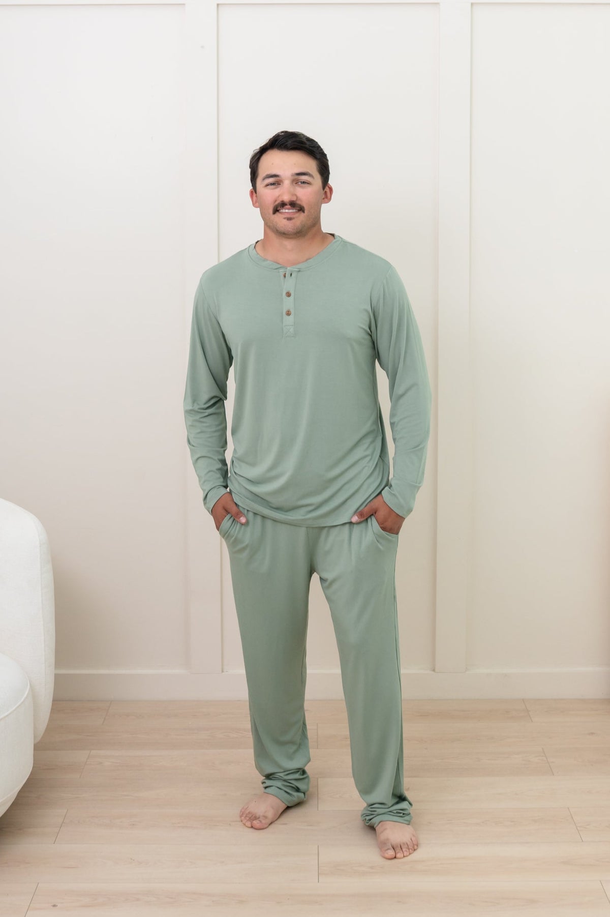 Male model standing with his hand in the Men's Lounge pant in Thyme paired with a matching Henley long sleeve