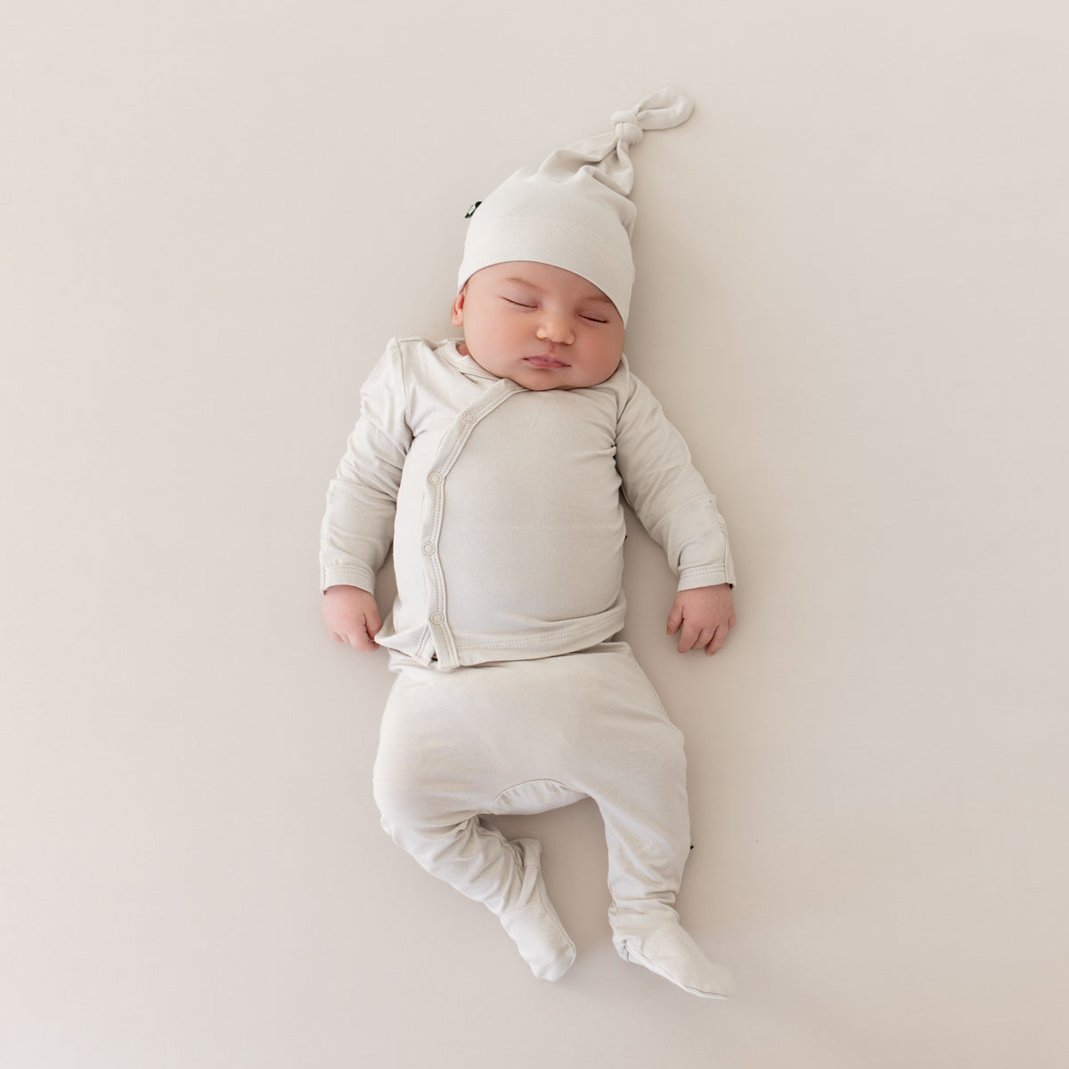 Baby sleeping in Newborn Take Me Home Set with Cap in Oat