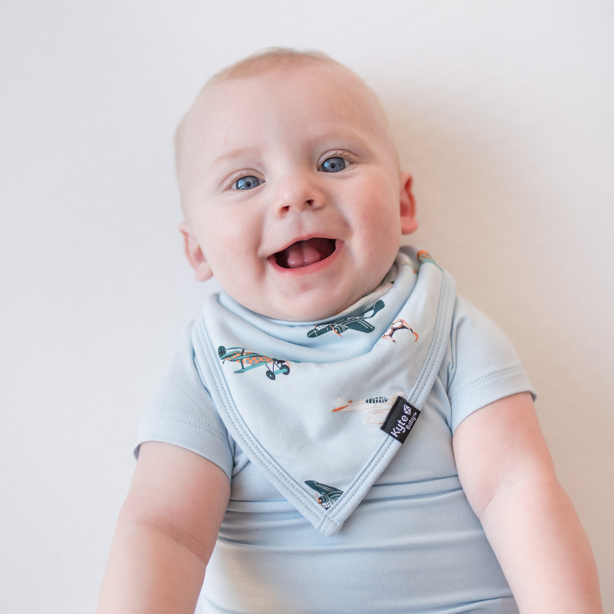 Close up of infant wearing the Bib in Take Off