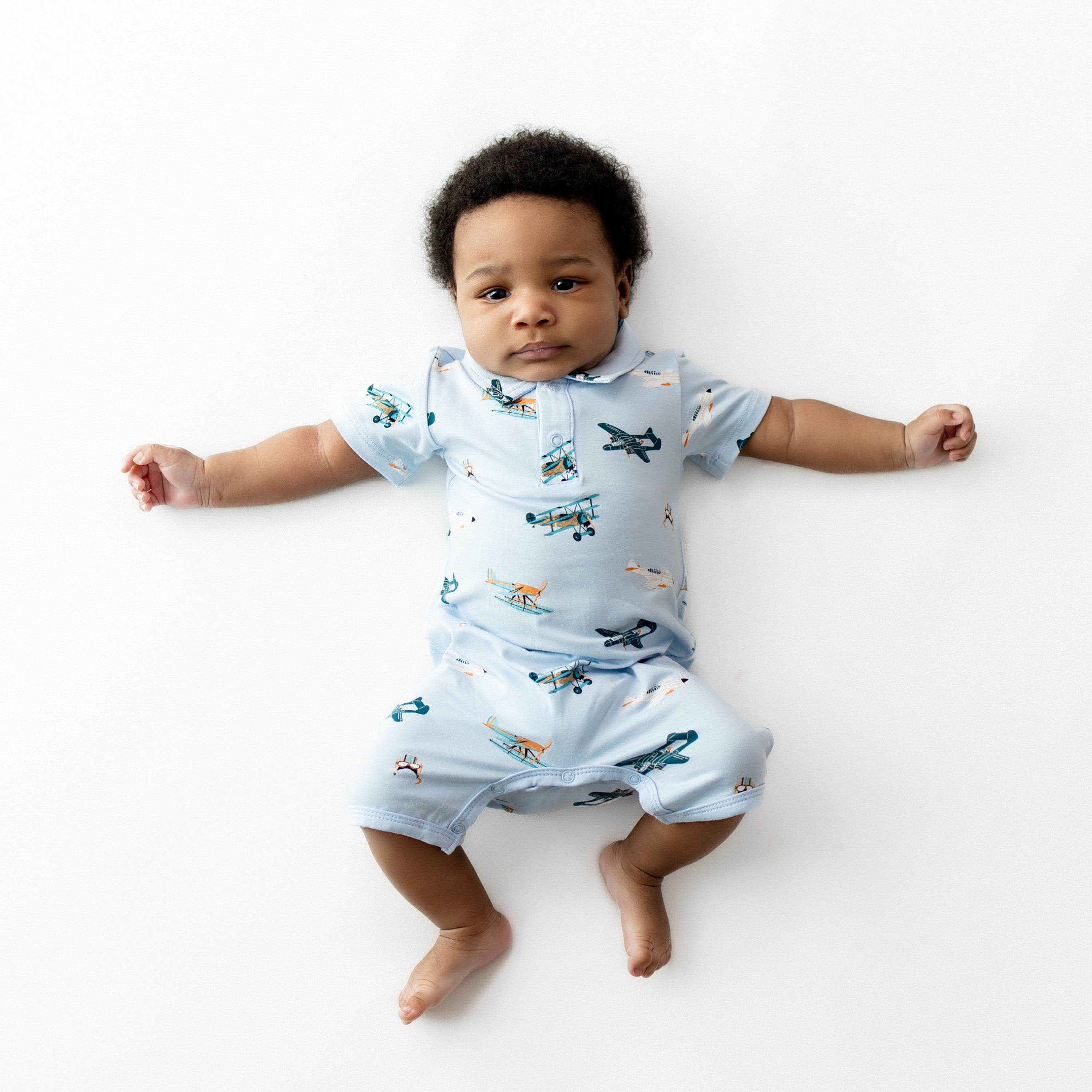 Infant laying stretched out wearing the Polo Shortall in Take Off