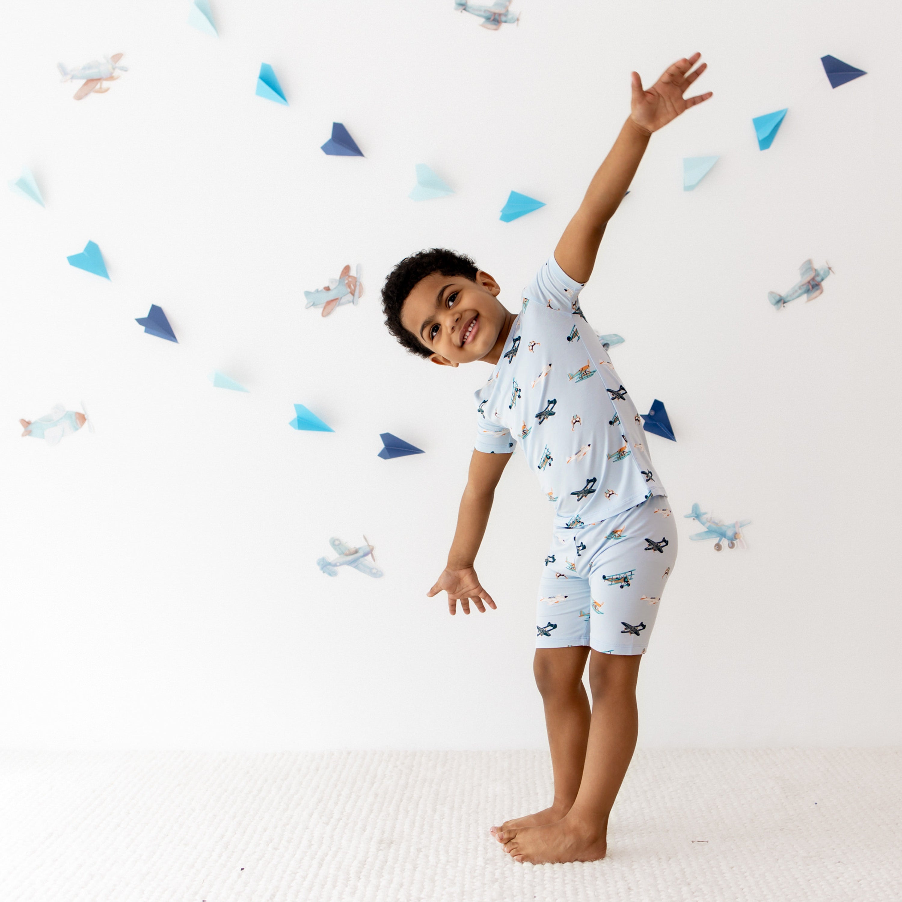Young boy with his arms stretched out wearing the Short Sleeve Pajamas in Take Off