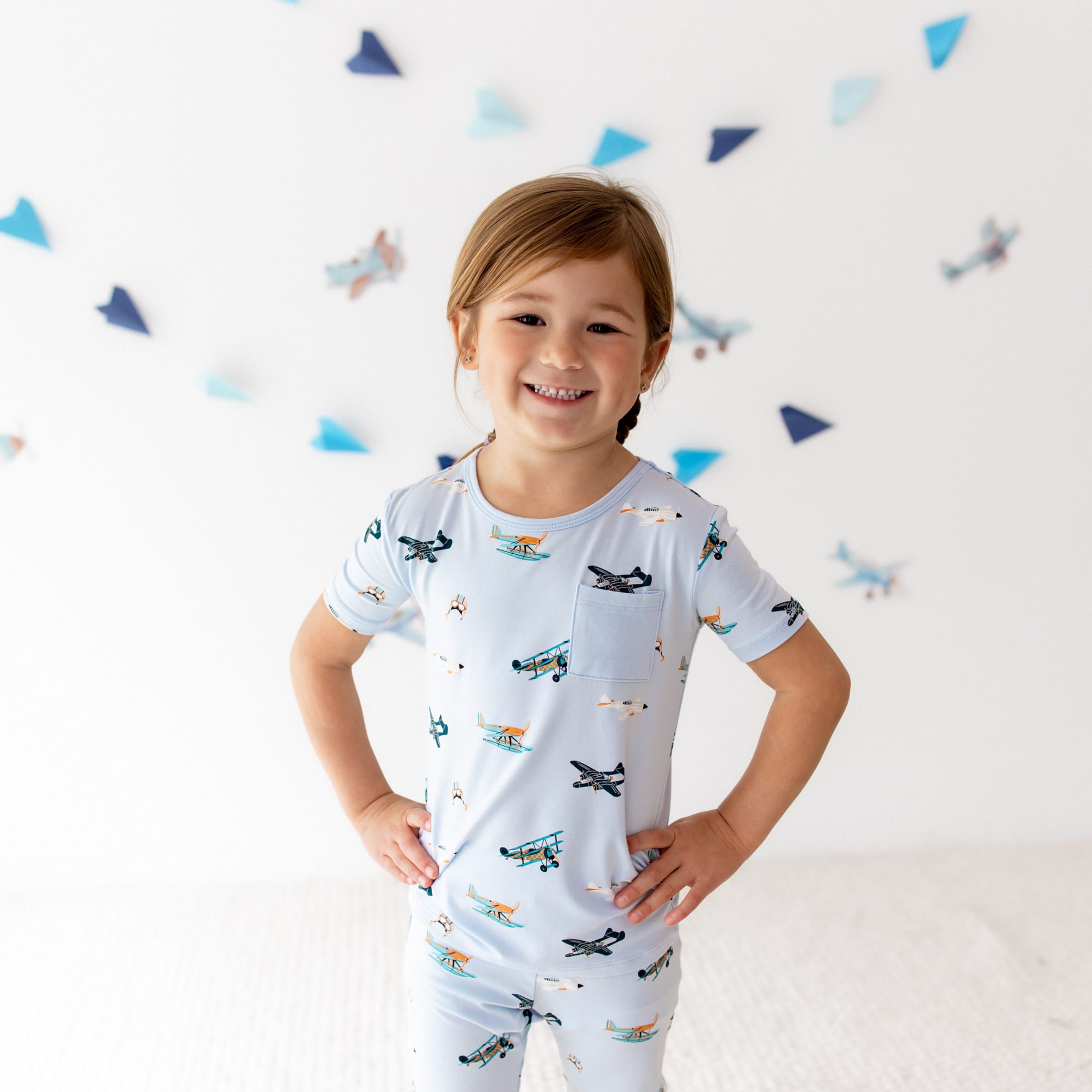 Close up of smiling girl standing with both hands on her hips wearing the Short Sleeve with Pants Pajamas in Take Off