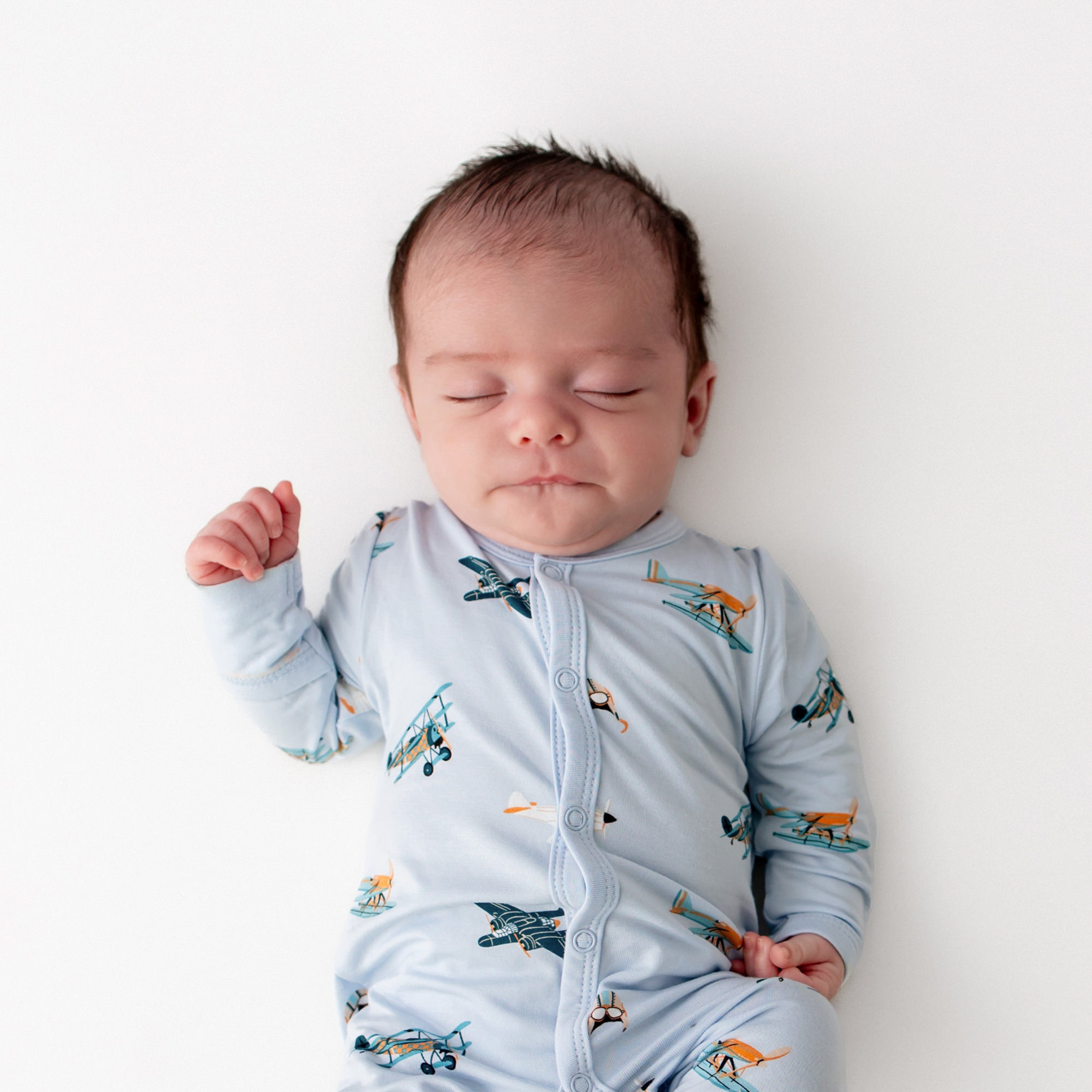 Close up of sleeping newborn wearing the Romper in Take Off