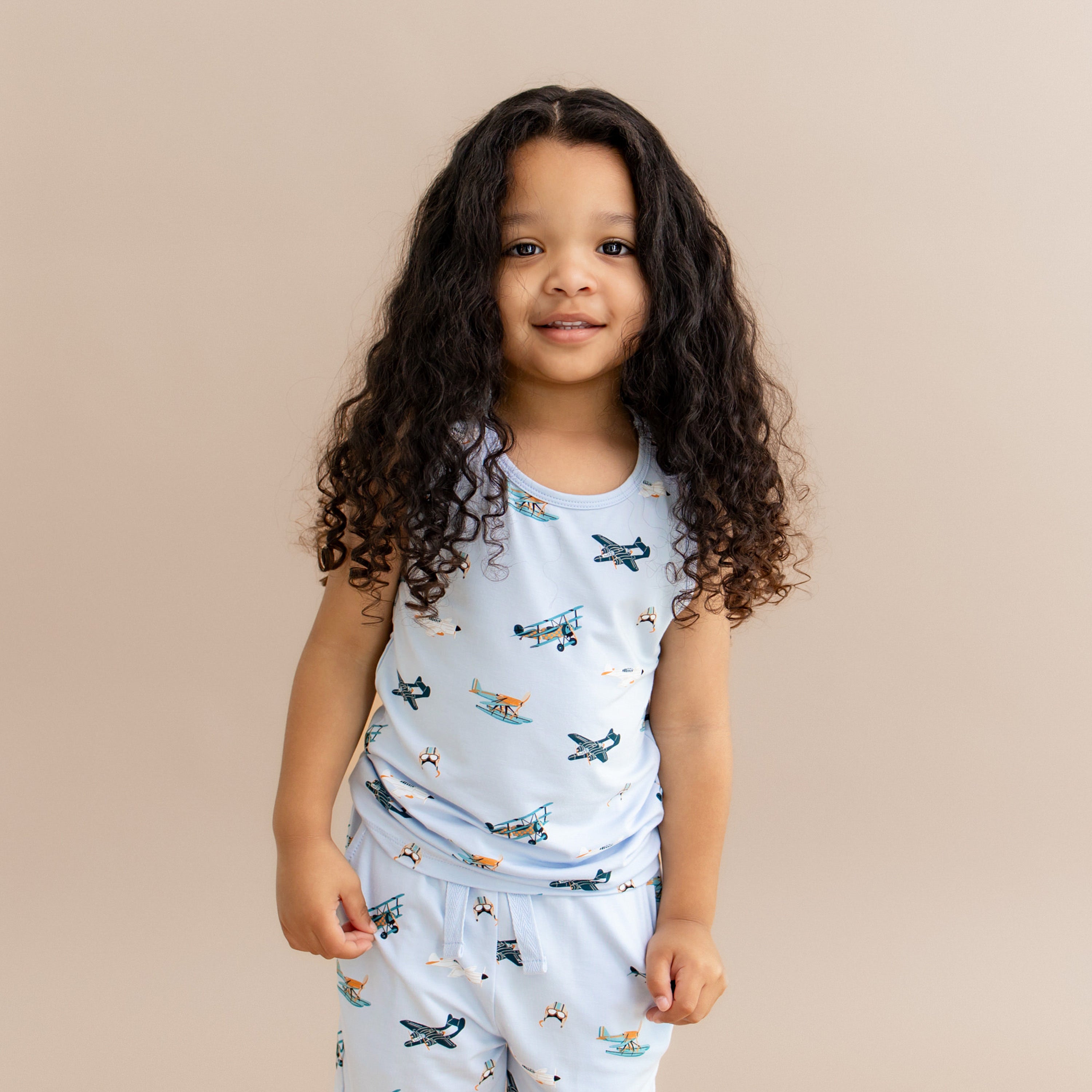 Young girl wearing the Toddler Tank Top in Take Off paired with matching drawstring shorts