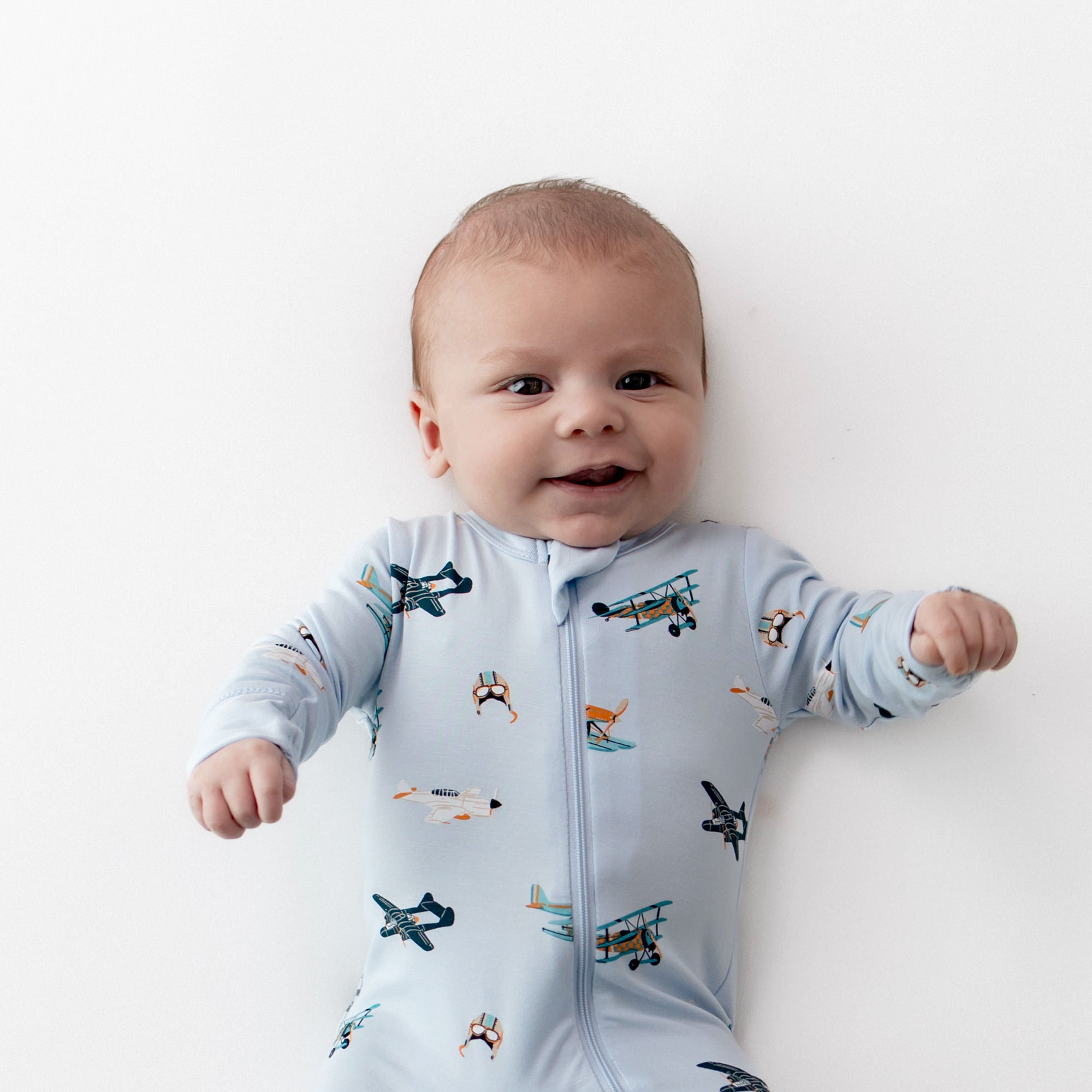 Close up of infant wearing the Zippered Footie in Take Off