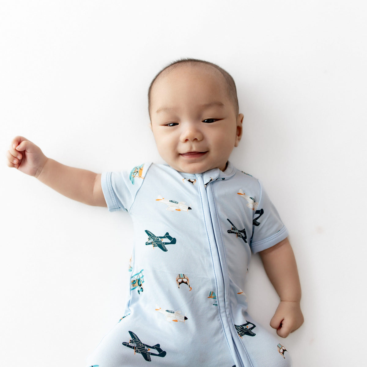 Close up of infant wearing the Zipper Shortall Romper in Take Off