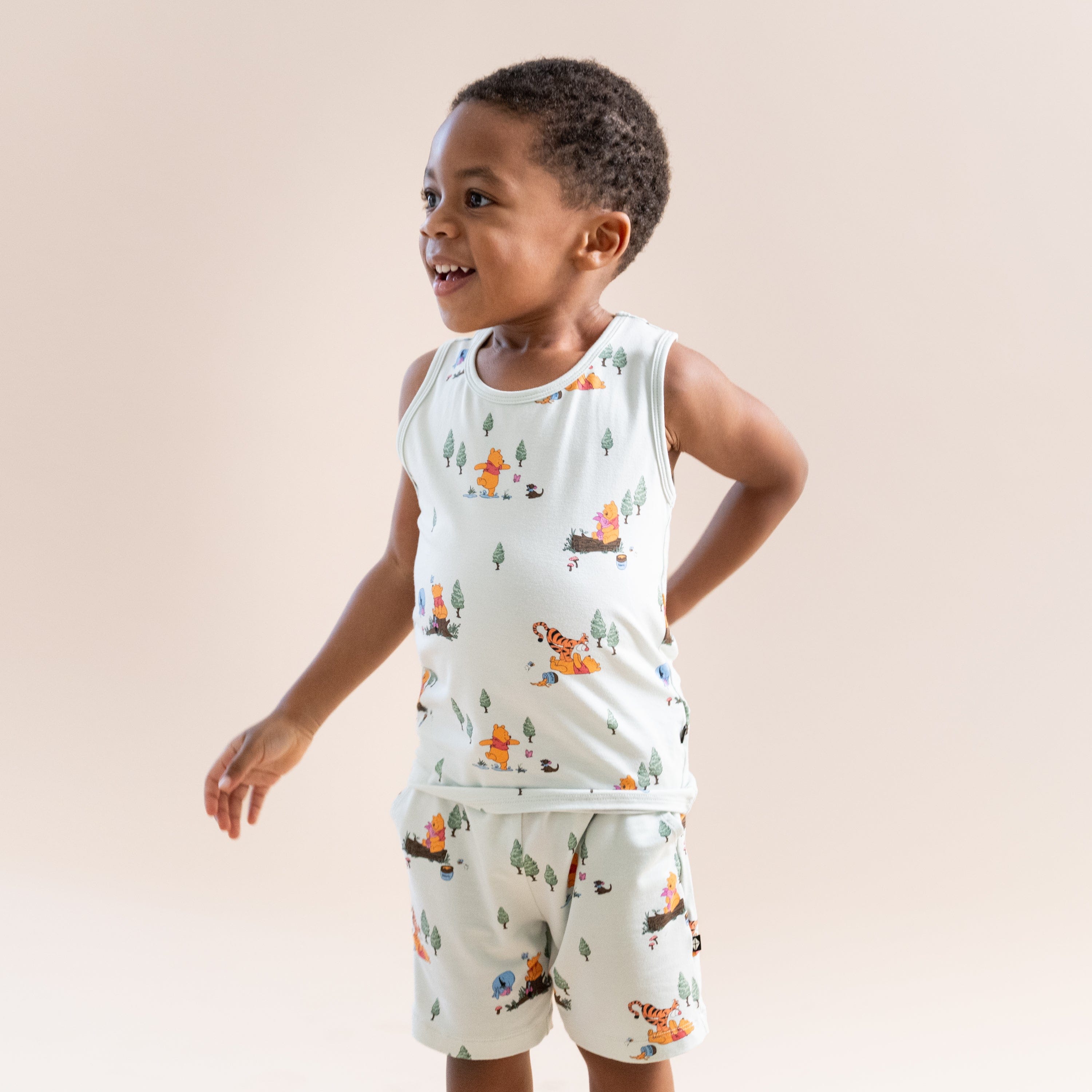 Young boy modeling the Toddler Tank Top in Winnie the Pooh Hundred Acre Wood with matching drawstring shorts