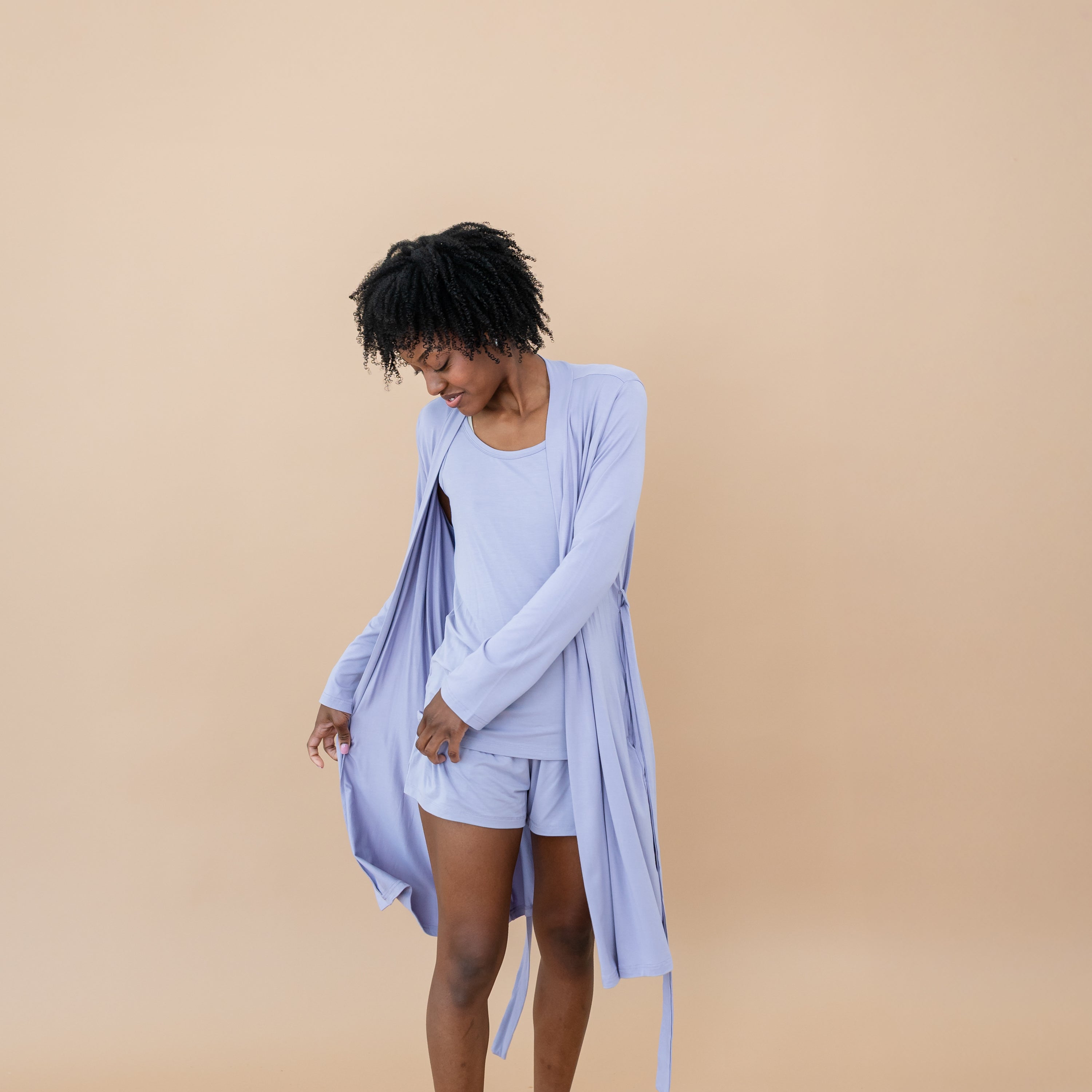 Female model holding the side hem of the Women’s Lounge Robe in Taro wearing the Taro Women's Tank Set underneath