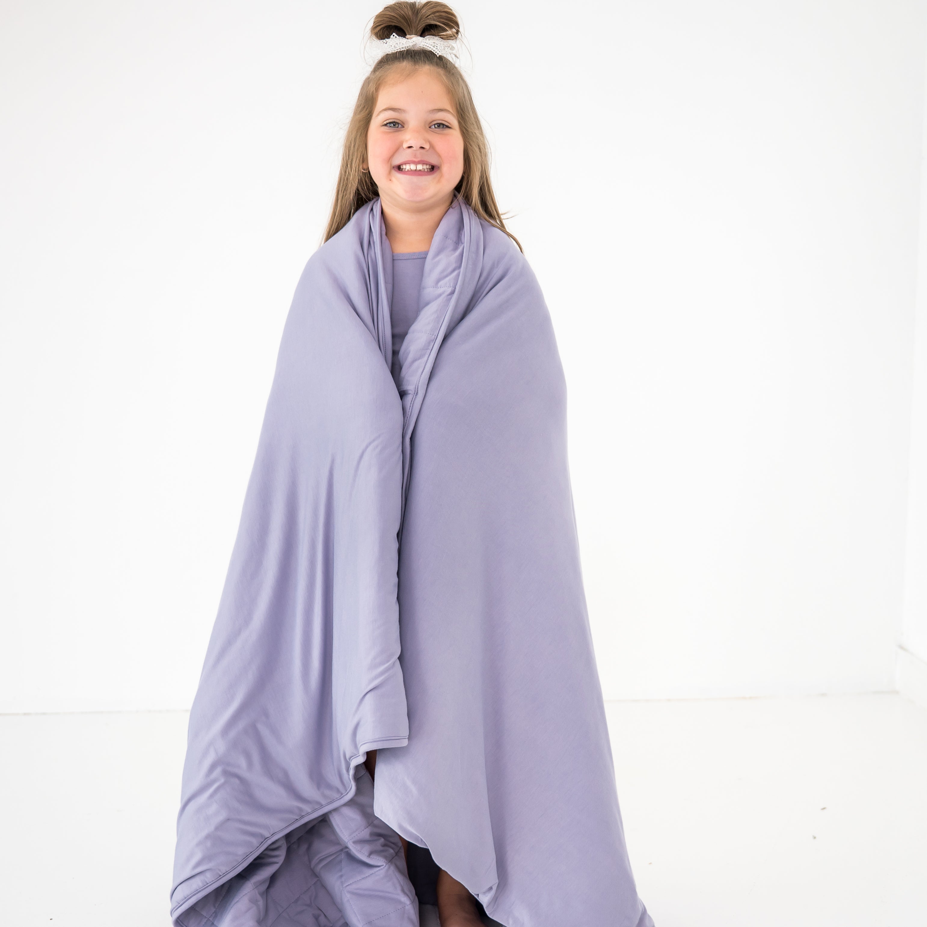 Child wrapped in a creamy purple color bamboo blanket