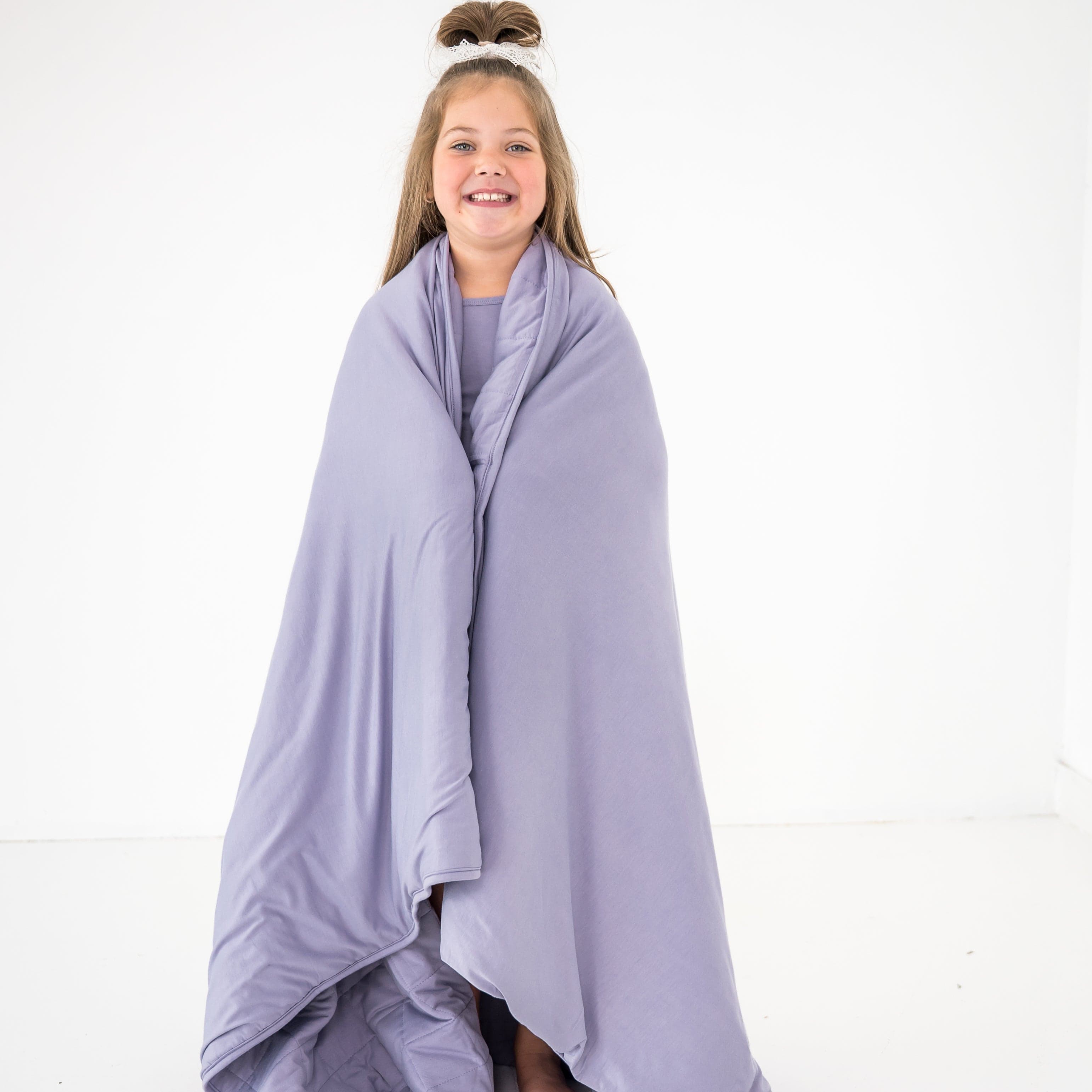 Child wrapped in a creamy purple color bamboo blanket