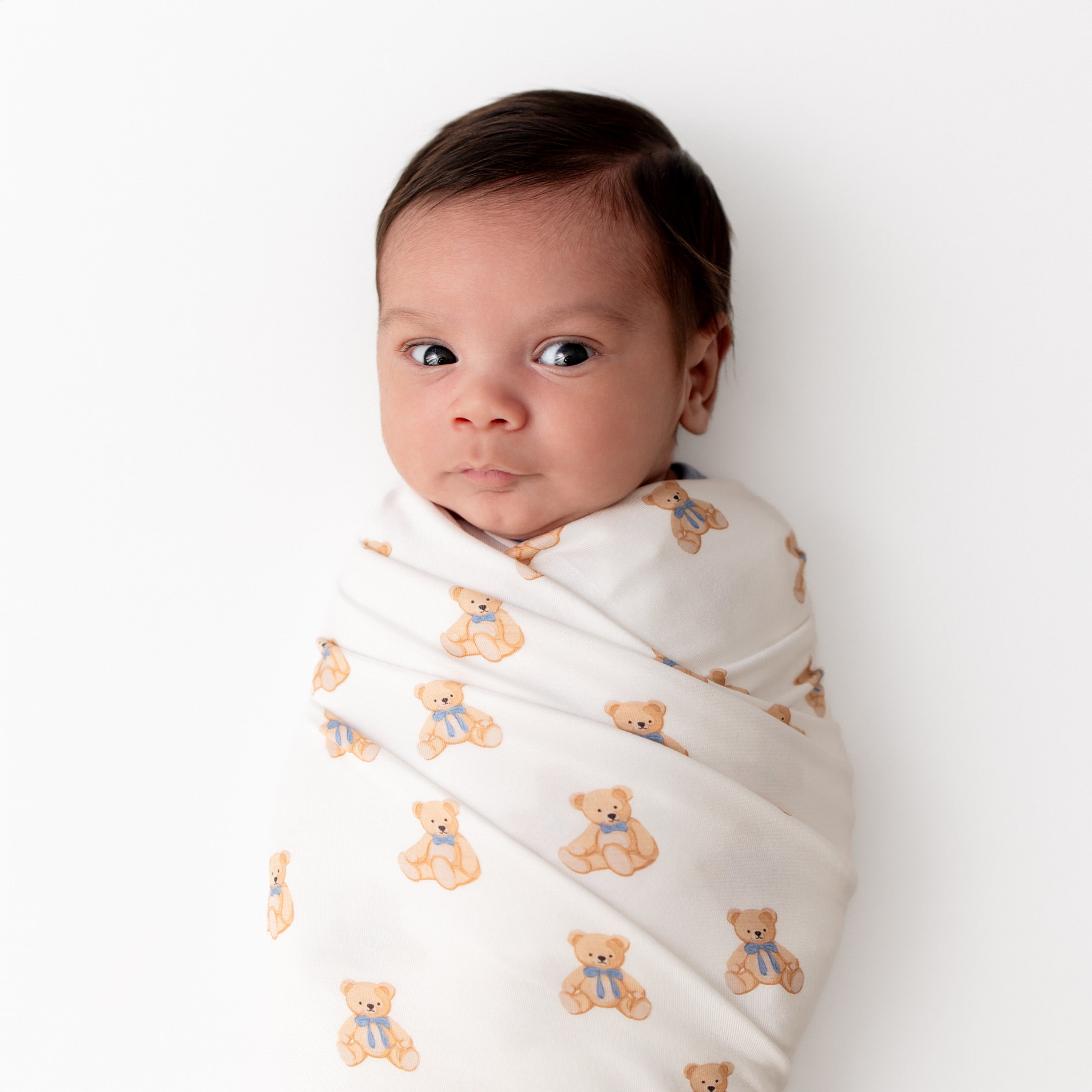 Baby swaddled in a teddy bear printed blanket