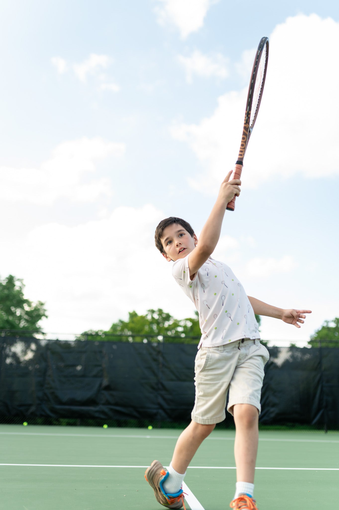 Child playing tennis on a court with a racket