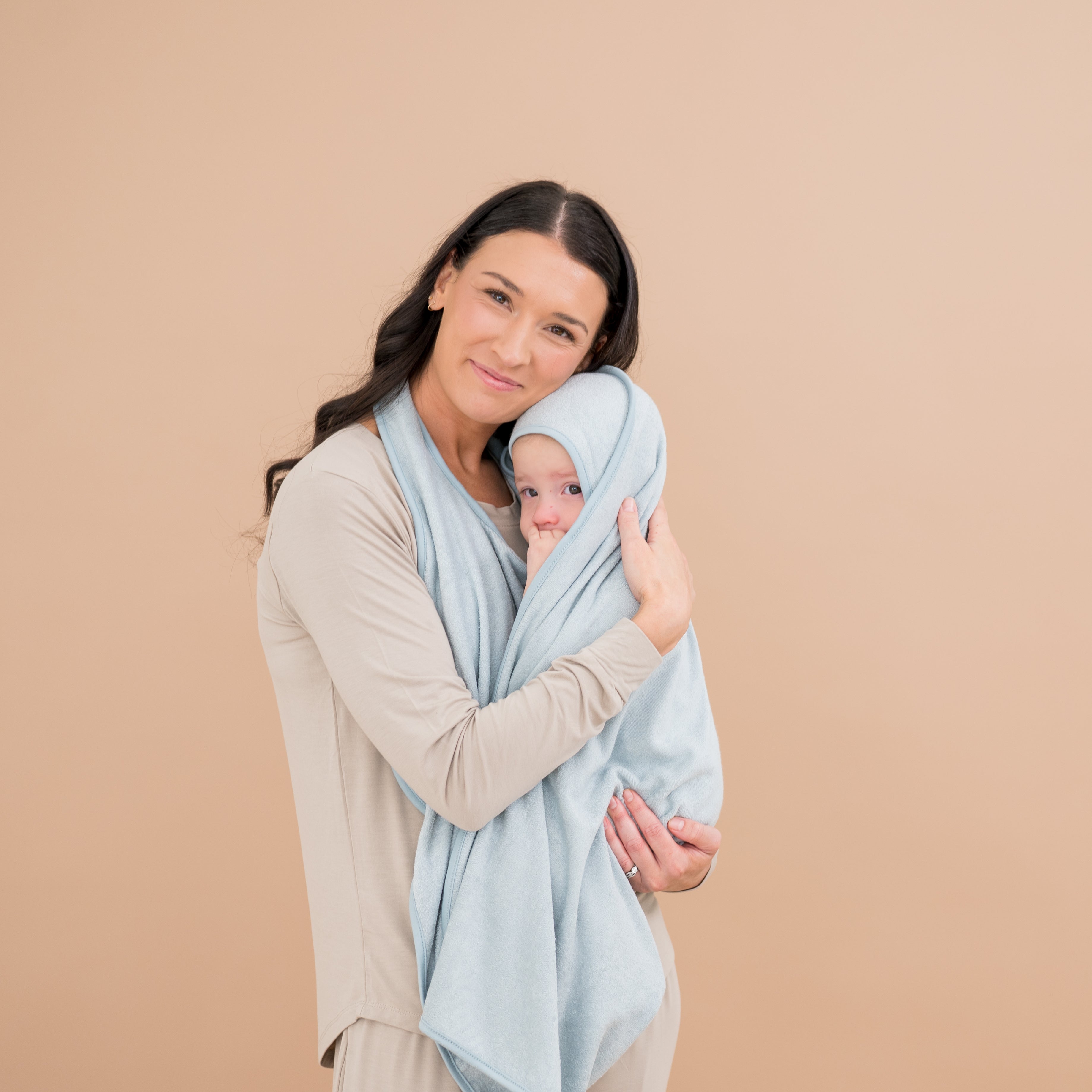 Mom holding baby wrapped in Bamboo Terry Apron Towel in Fog