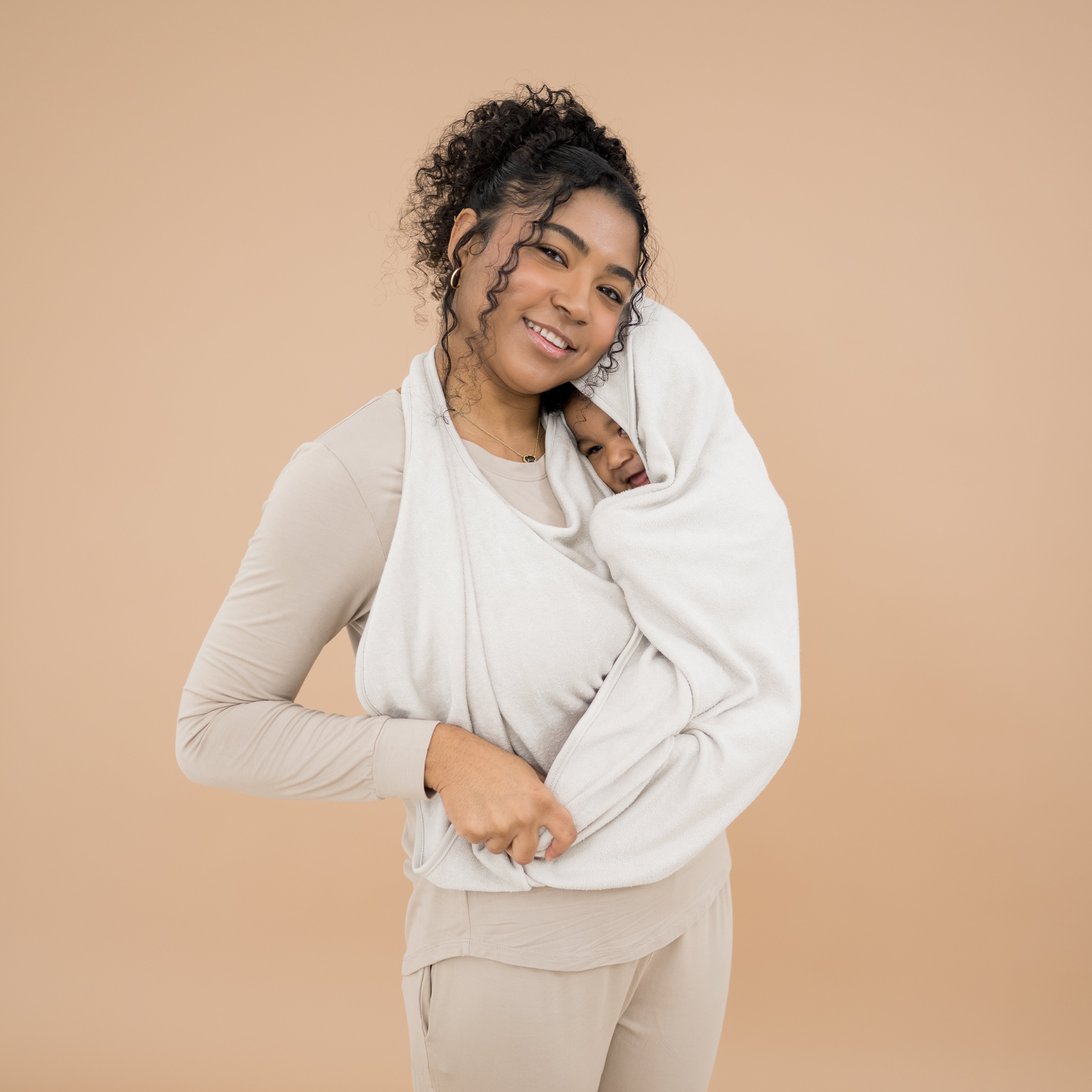 Mother using Off-white Terry Apron Towel to wrap baby after bath