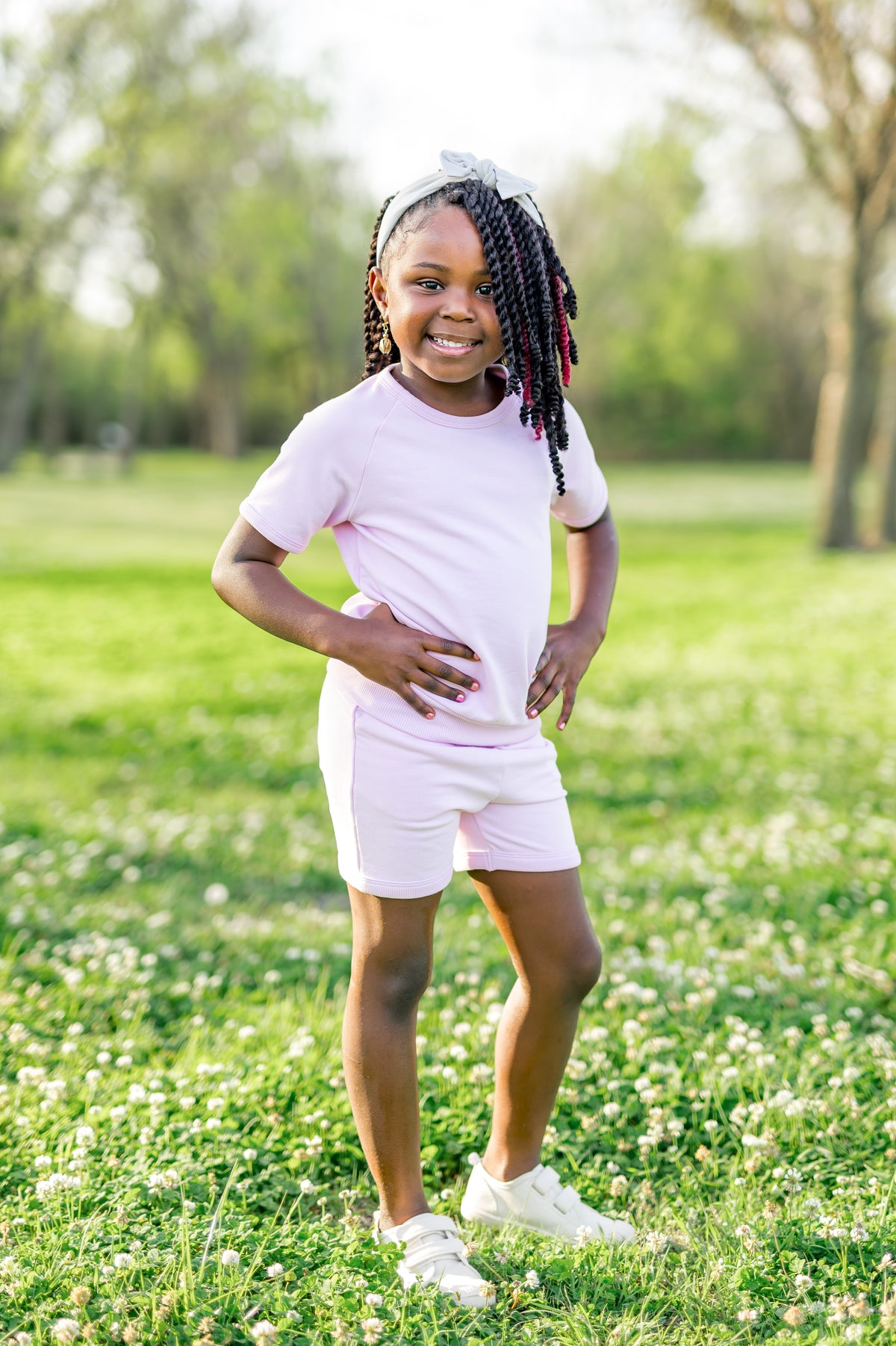 Young girl posing in a field wearing the Short Sleeve Jogger Set in Thistle