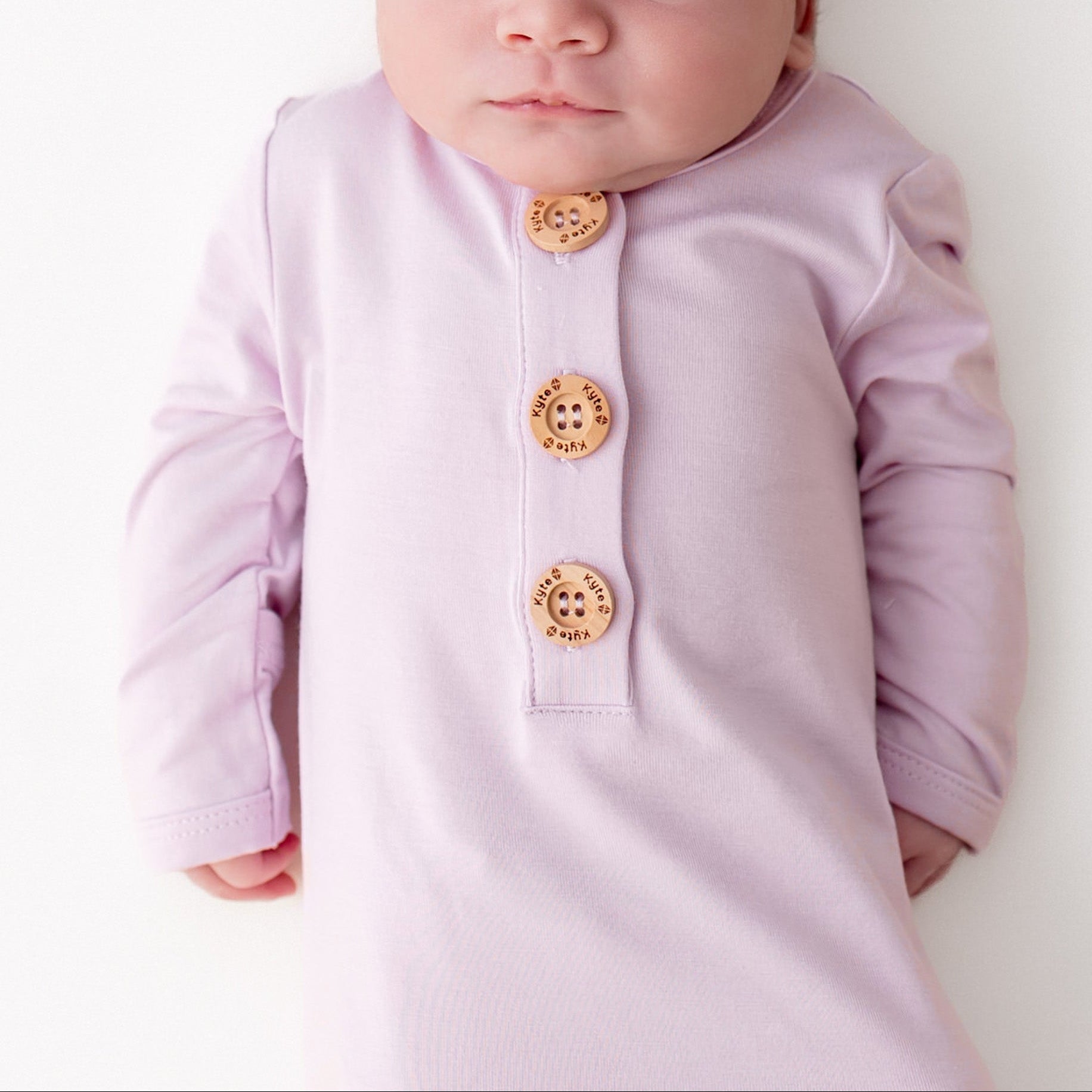 Close up of newborn wearing the Knotted Gown with Hat Set in Thistle
