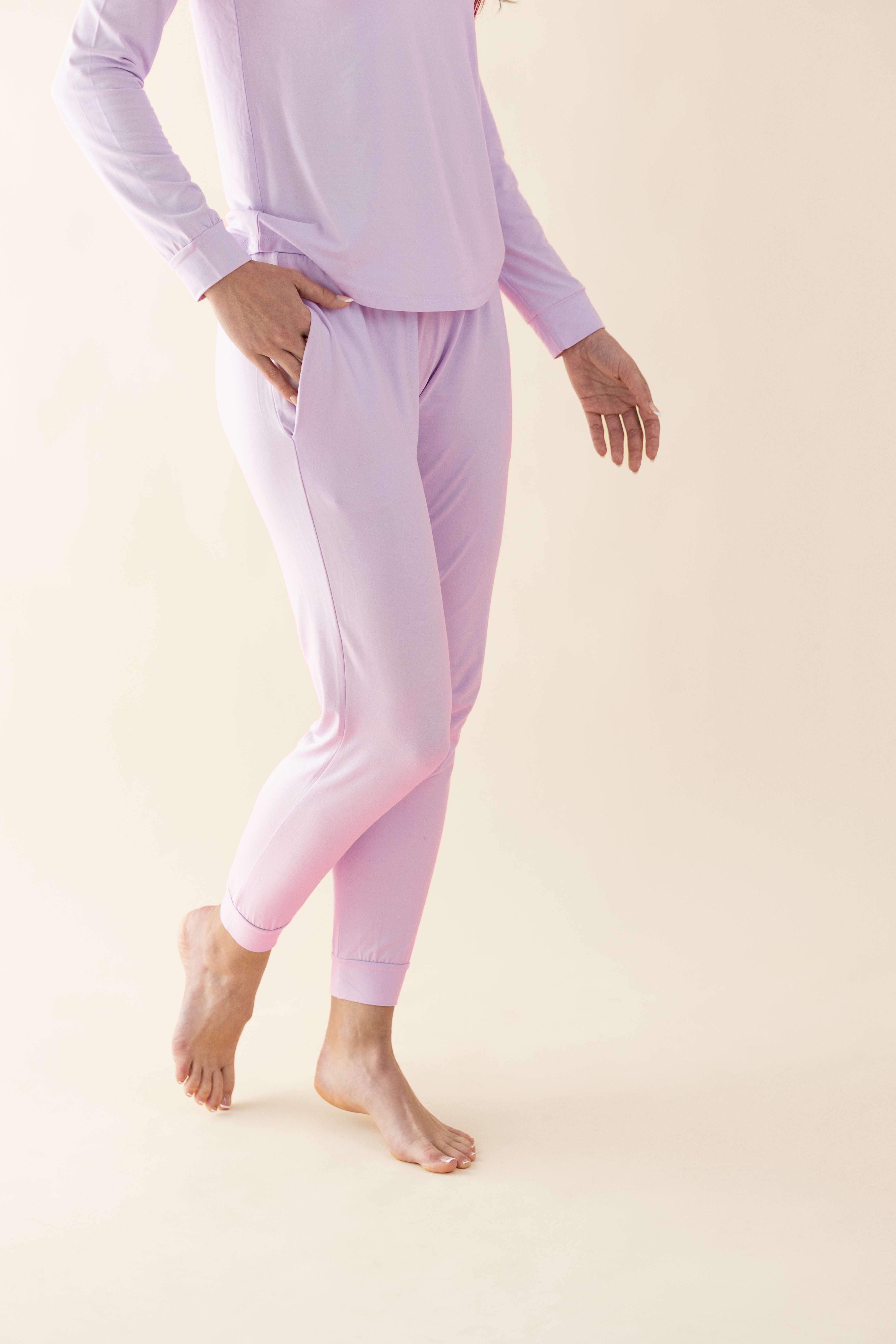 Person wearing light purple pajama set on a beige background