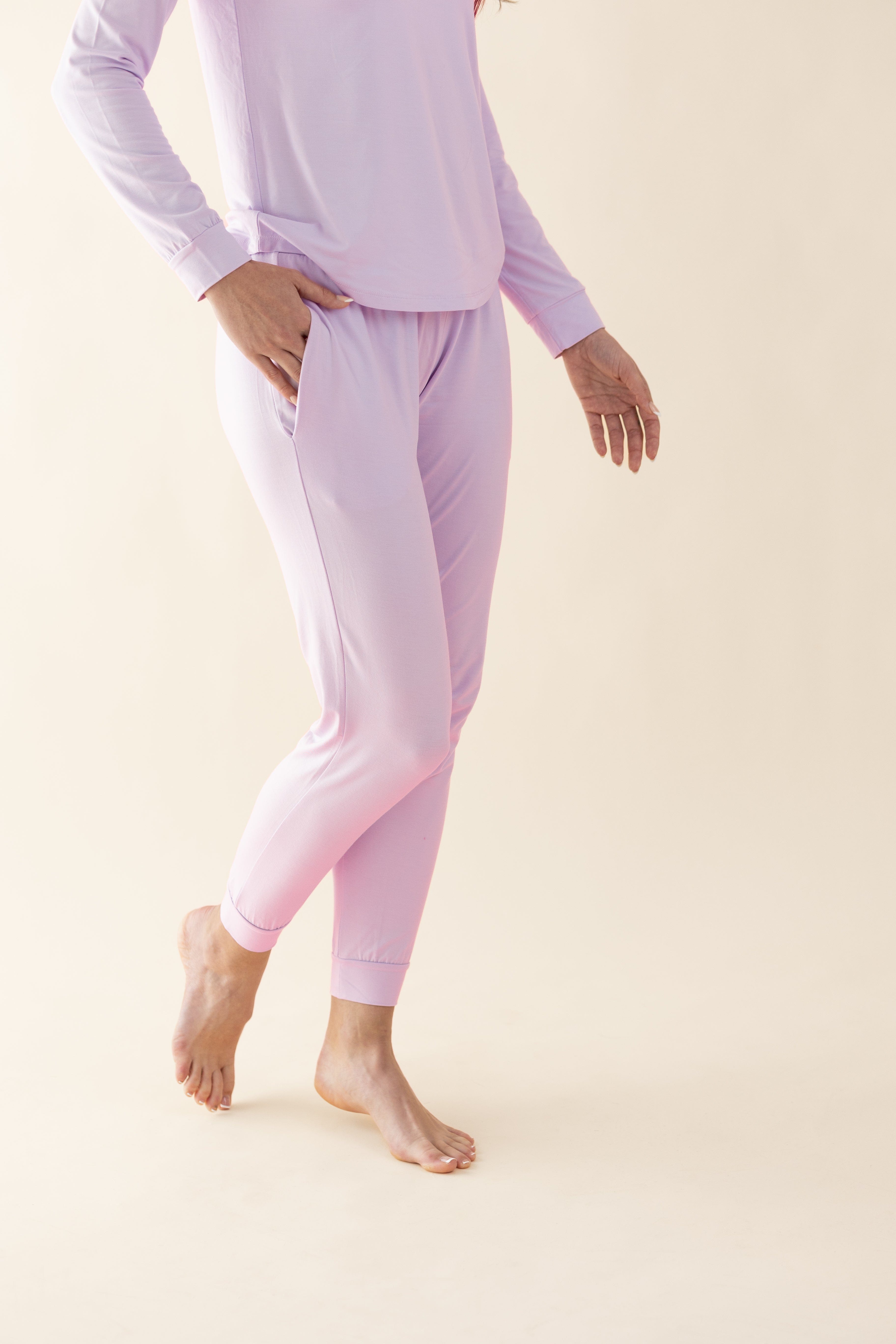 Person wearing light purple pajama set on a beige background
