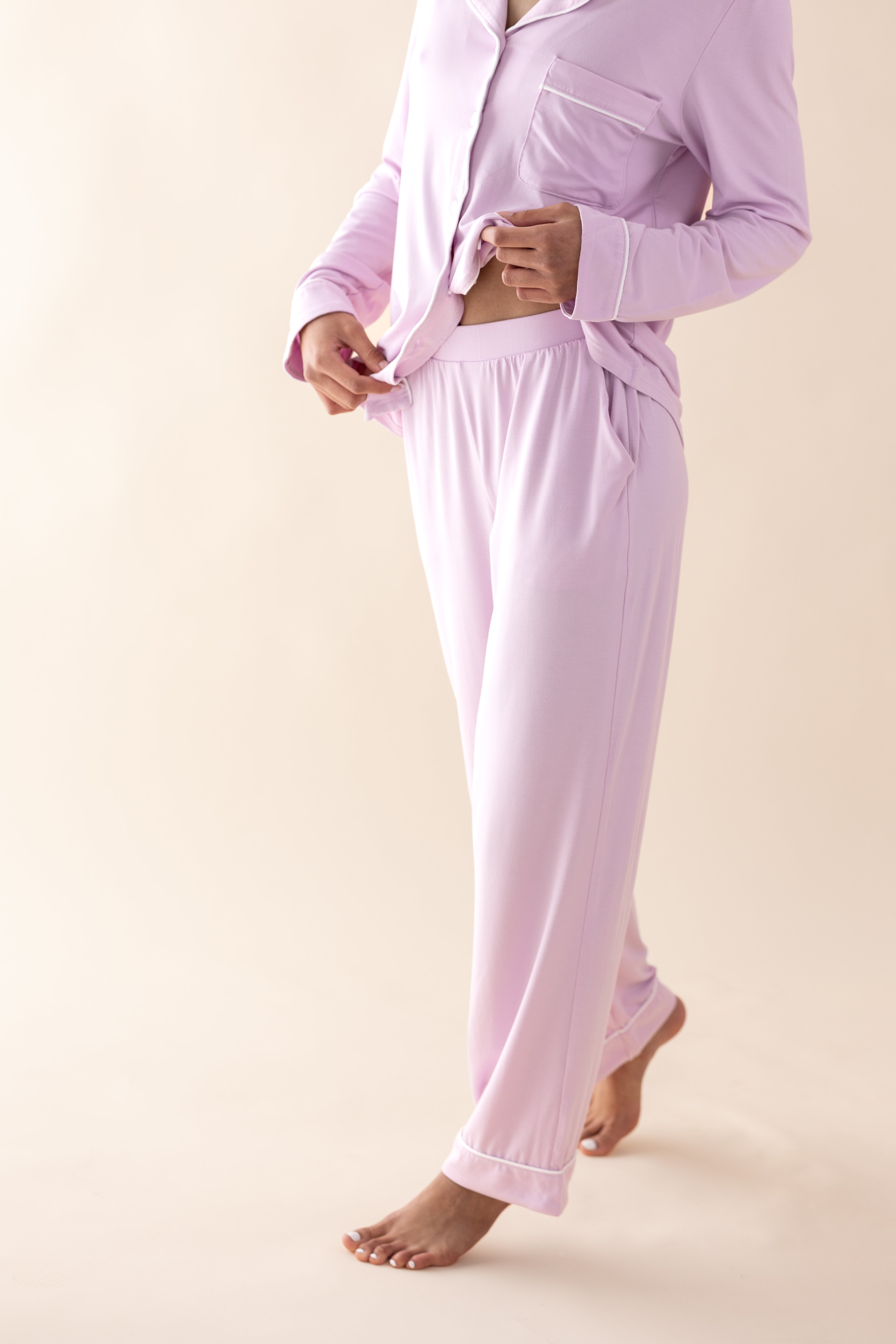 Person wearing a light pink pajama set on a beige background