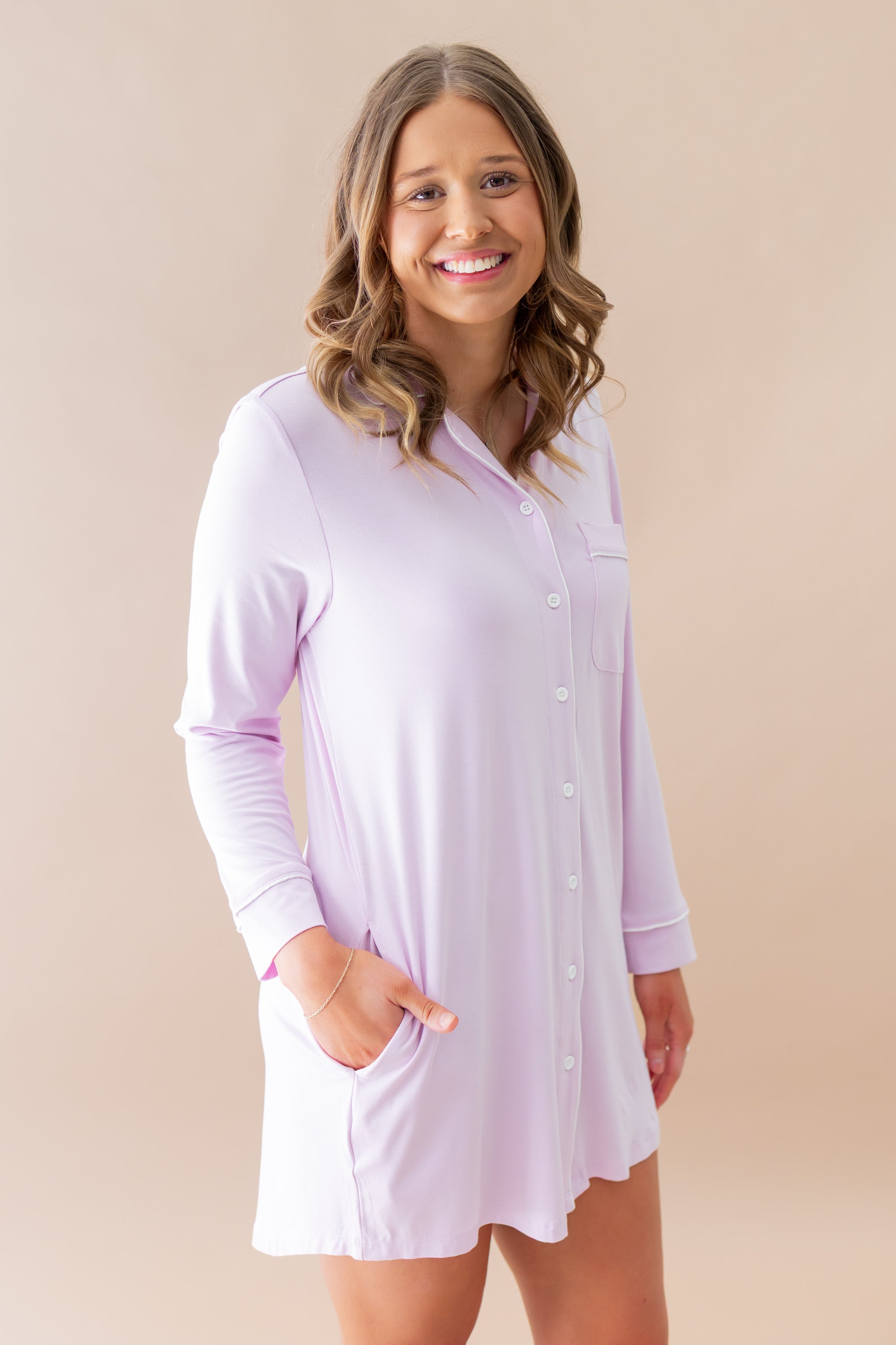 Smiling model wearing the Long Sleeve Women’s Nightshirt in Thistle with one hand in the pocket of the nightshirt