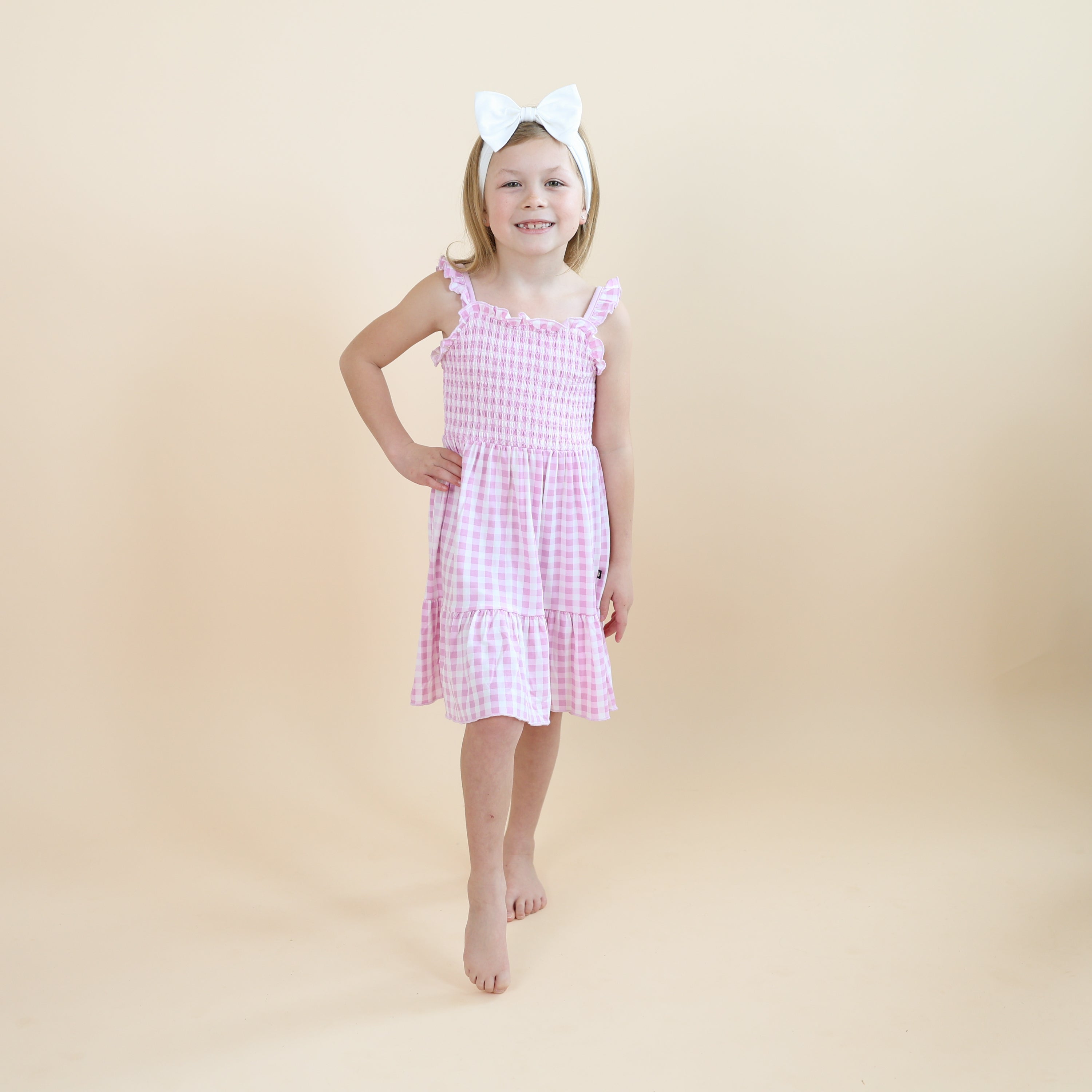 Young girl posing modeling the Smocked Dress in Gingham Thistle