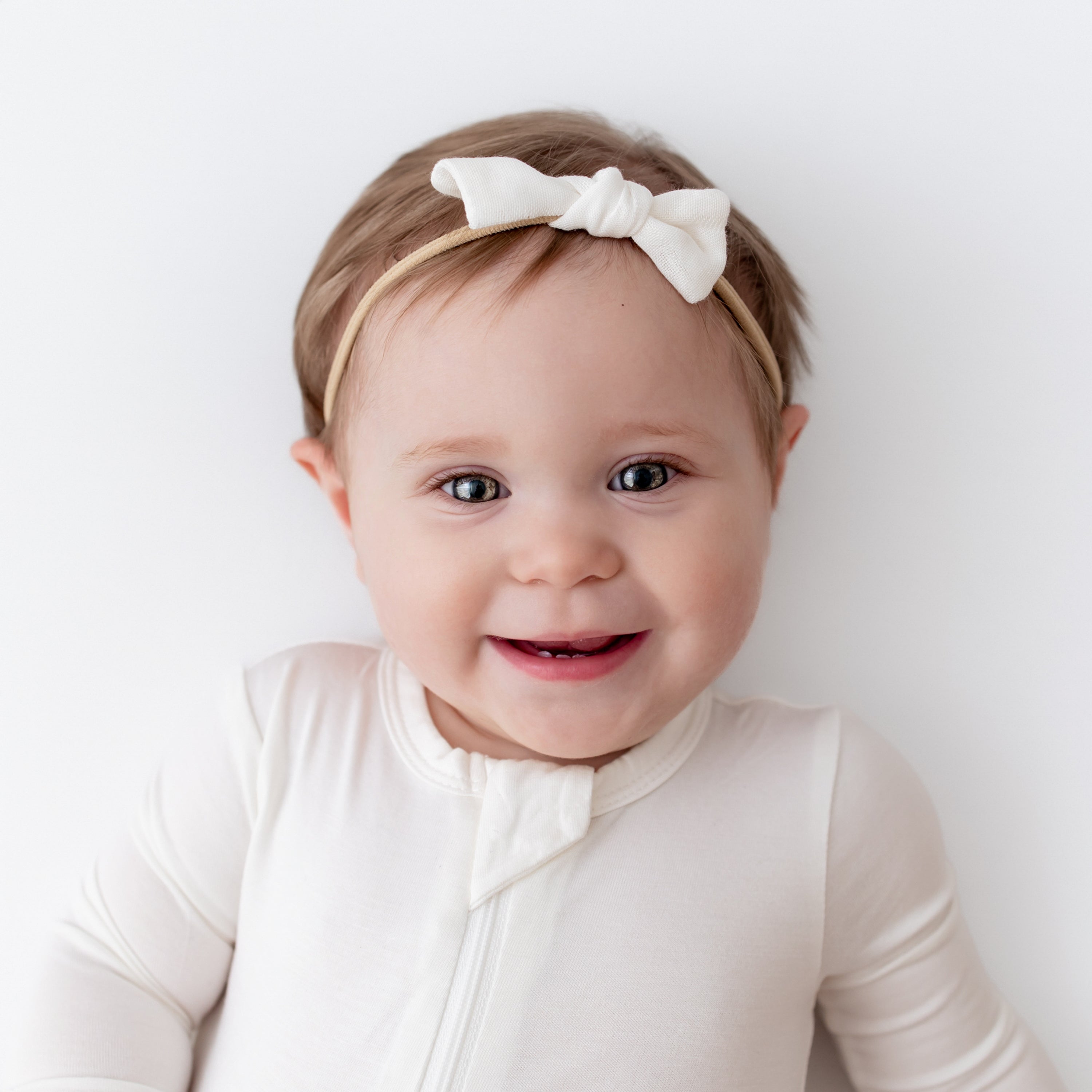 Baby wearing Bamboo Muslin Tiny Bow in Cloud and cloud romper