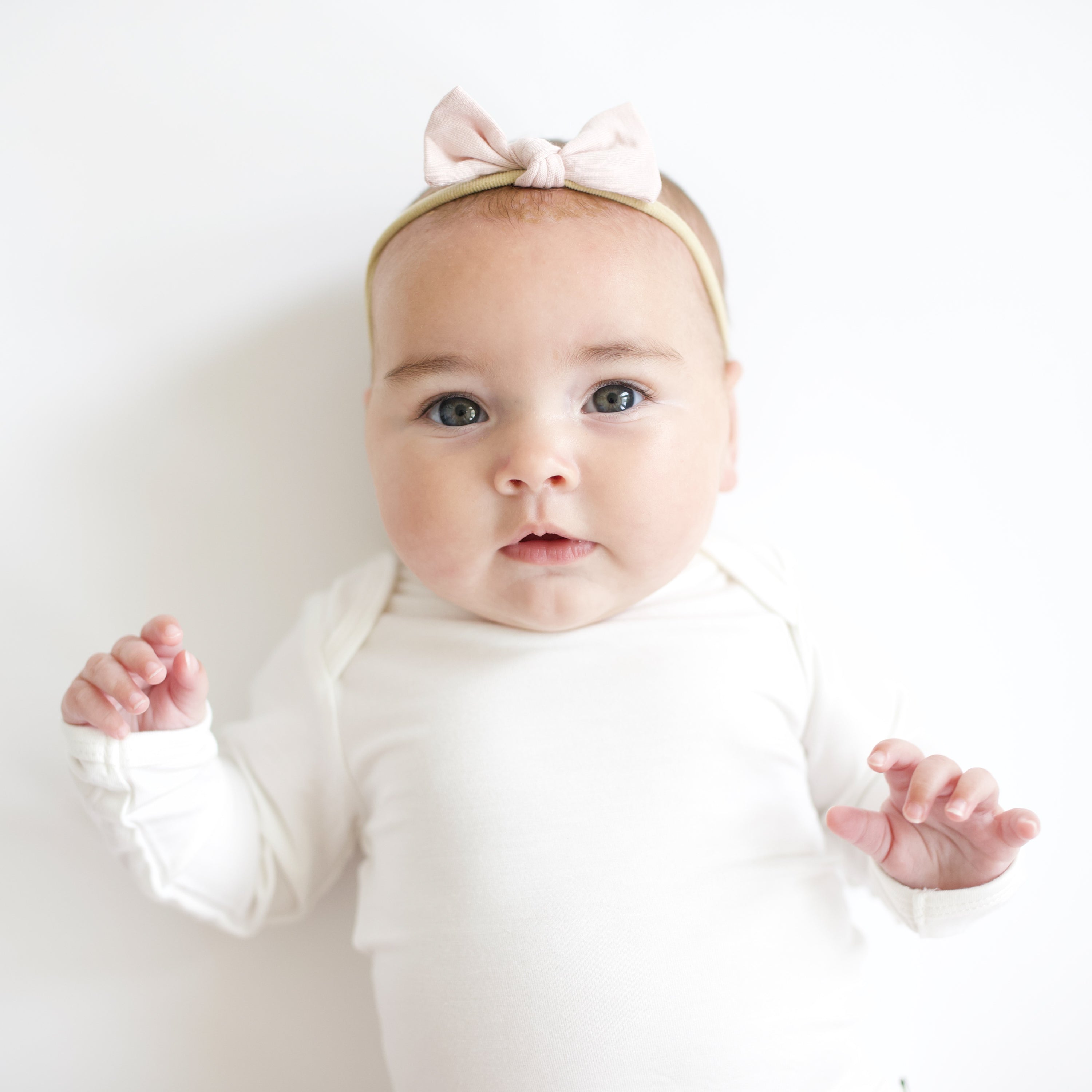 Close up of baby wearing Tiny Nylon Bow in Blush