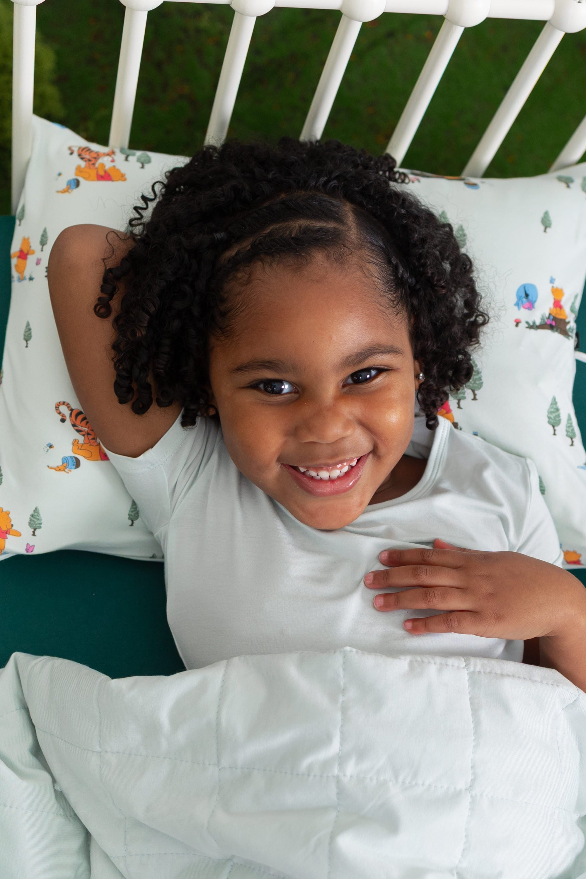Young girl laying in a bed on a Toddler Pillowcase in Winnie the Pooh Hundred Acre Wood