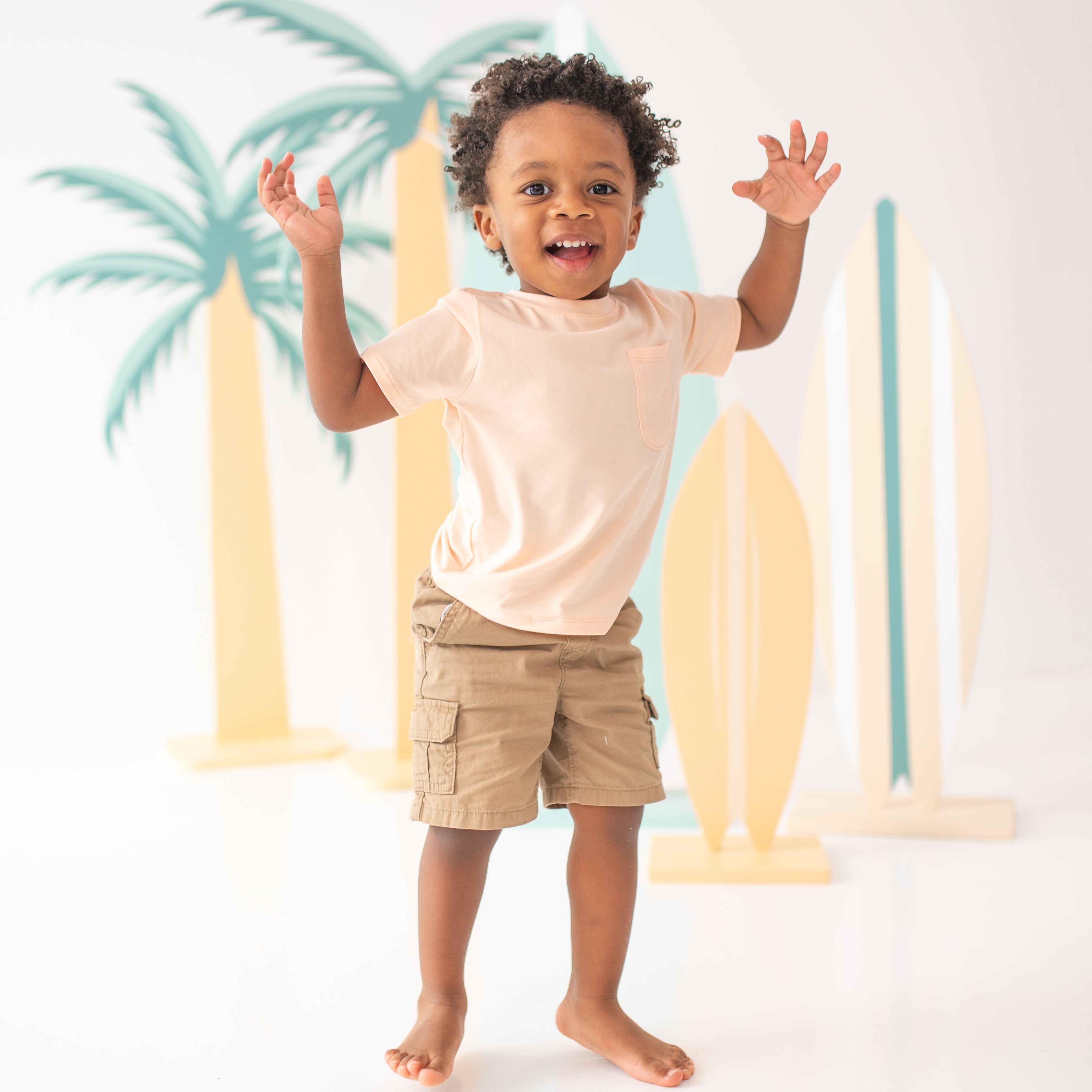 Toddler jumping with hands up in the air wearing the Toddler Crew Neck Tee in Canyon