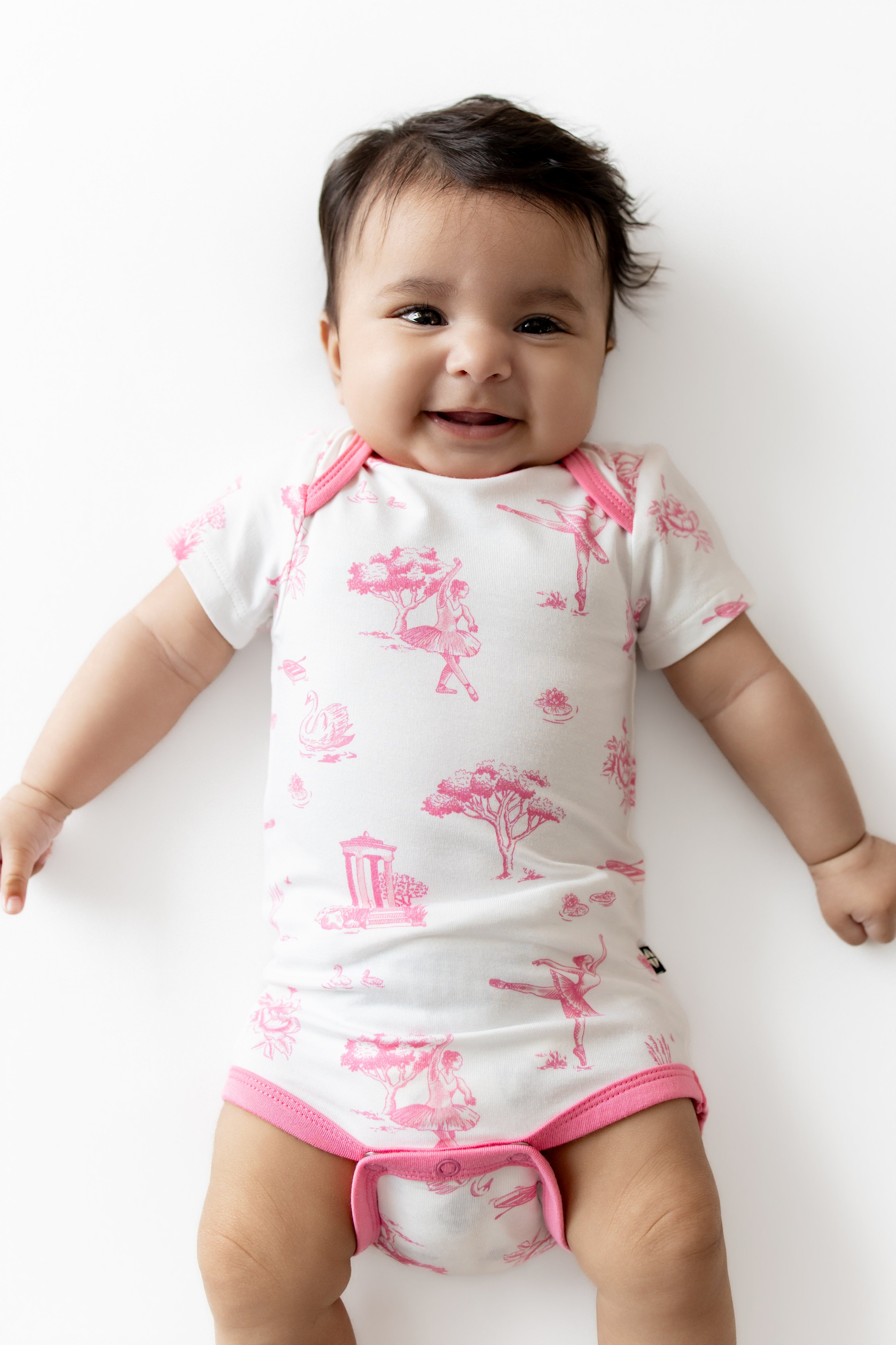 Smiling infant wearing the Bodysuit in Toile Ballet