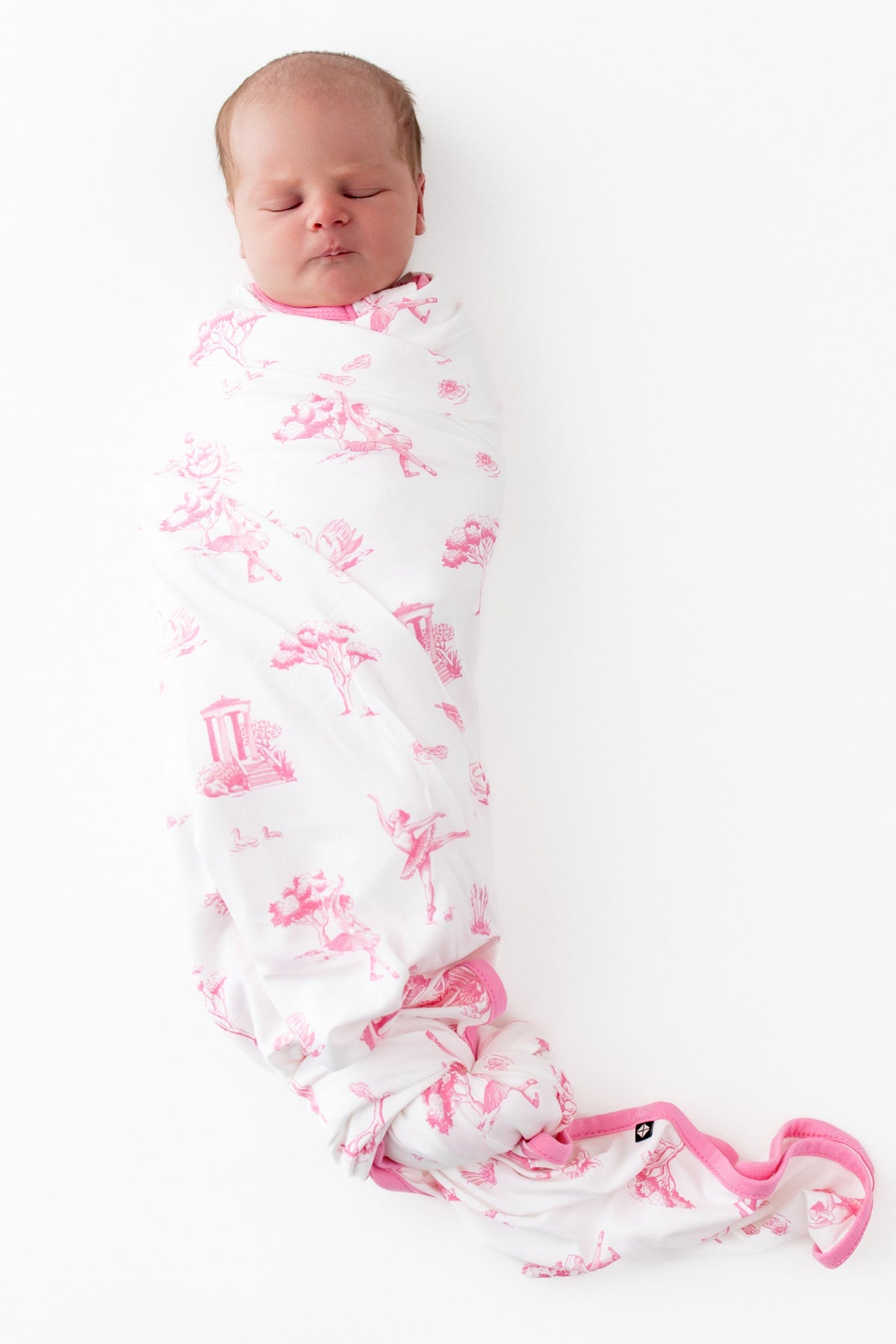 Sleeping newborn swaddled in the Swaddle Blanket in Toile Ballet