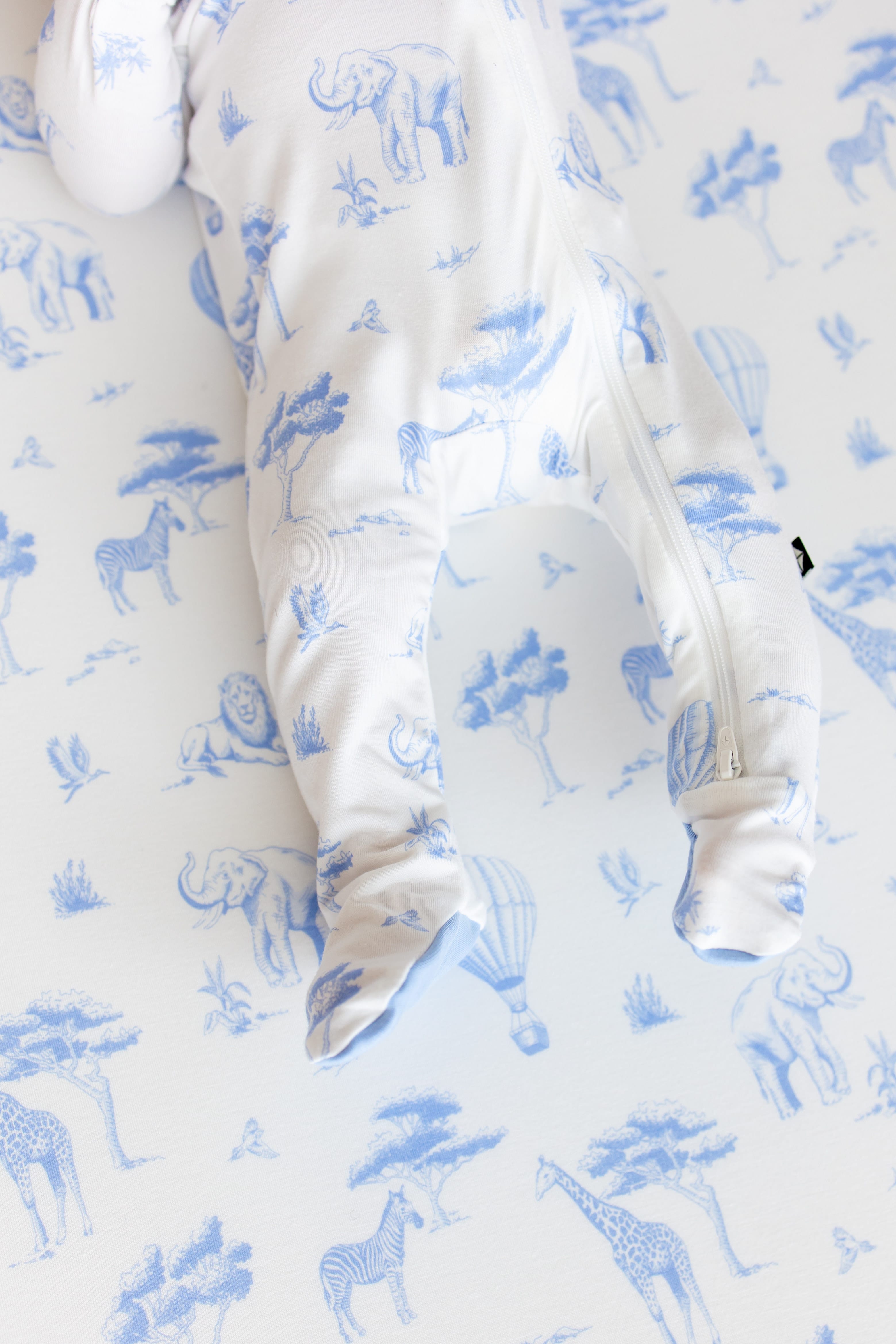Close up of the zipper closure and enclosed feet on the Zippered Footie in Toile Safari