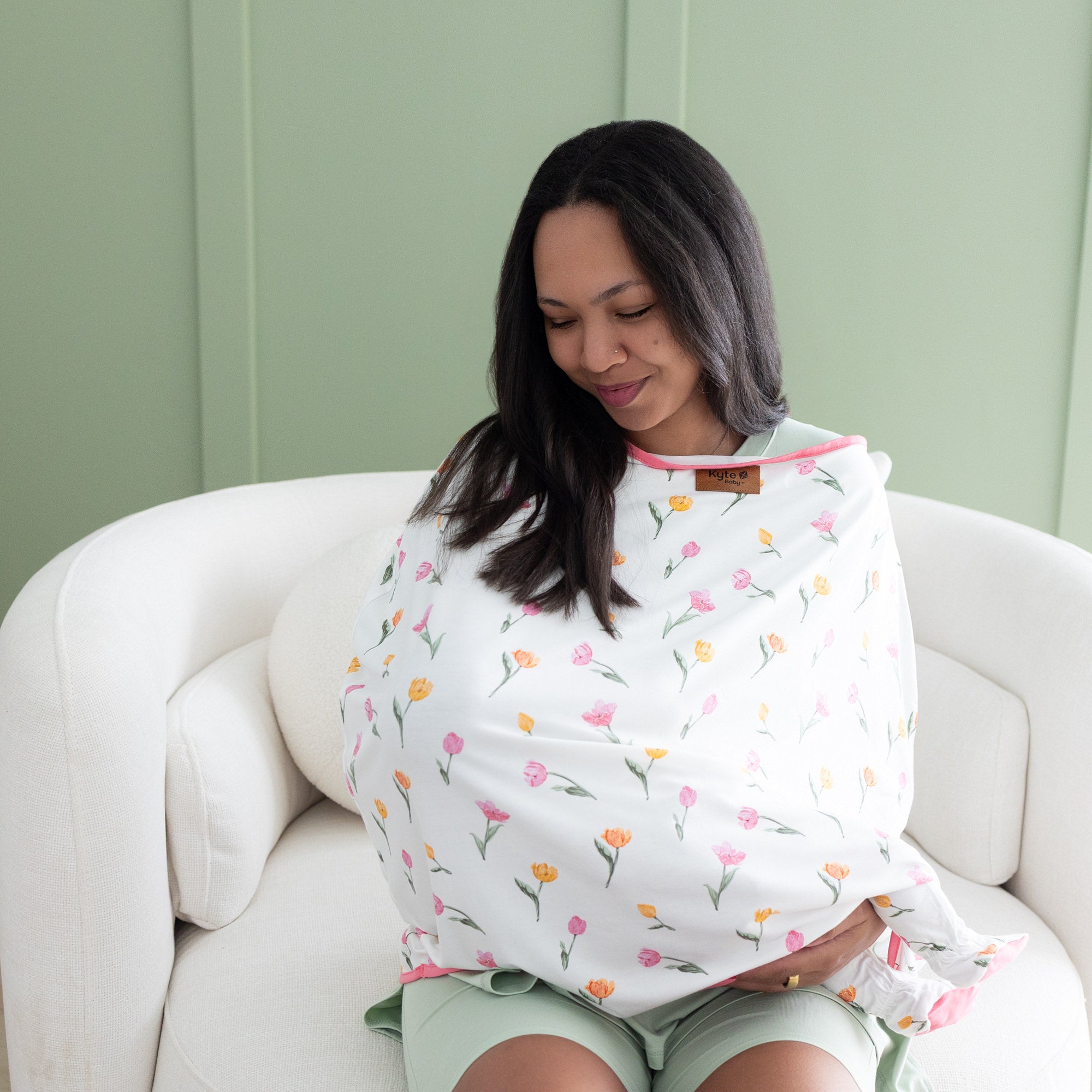 Close up of mother feeding her child with the Car Seat Cover in Tulip over her and her daughter