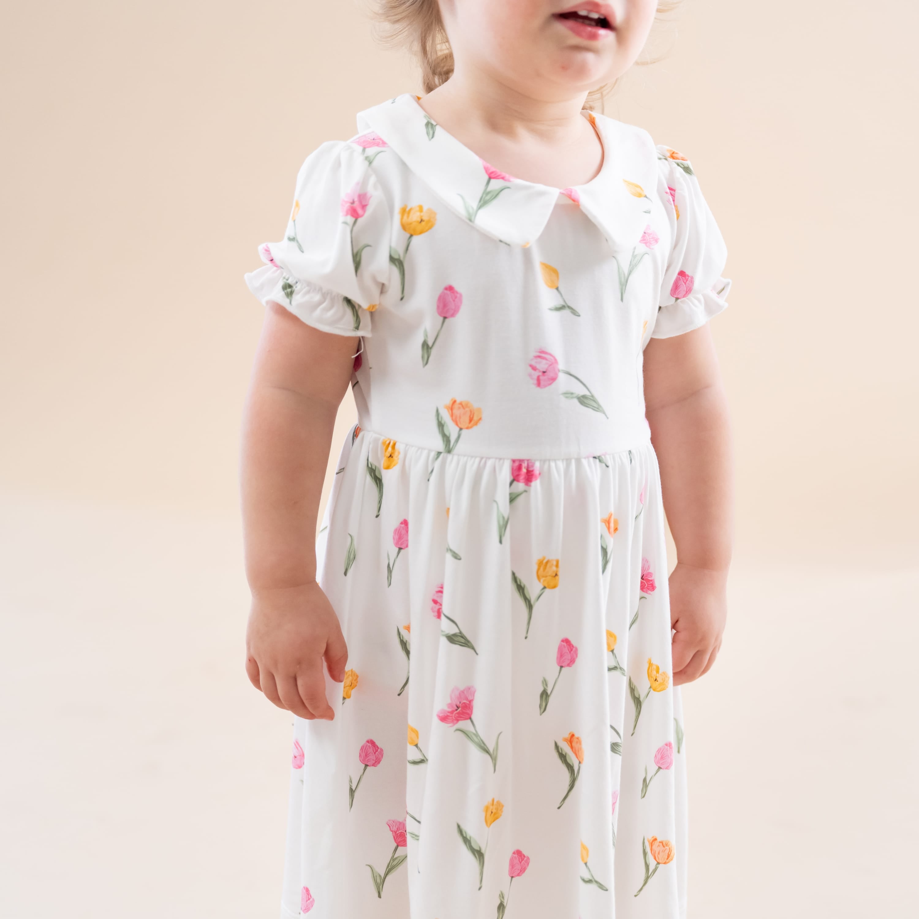 Close up of the Peter Pan Collar Bodysuit Dress in Tulip showing the puff sleeves and collared neck